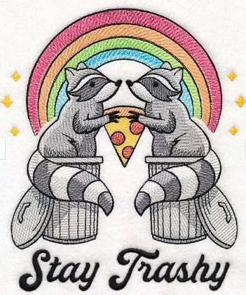 Two raccoons sitting in trash cans, holding a slice of pizza between them, under a rainbow, with the text 'Stay Trashy' at the bottom.