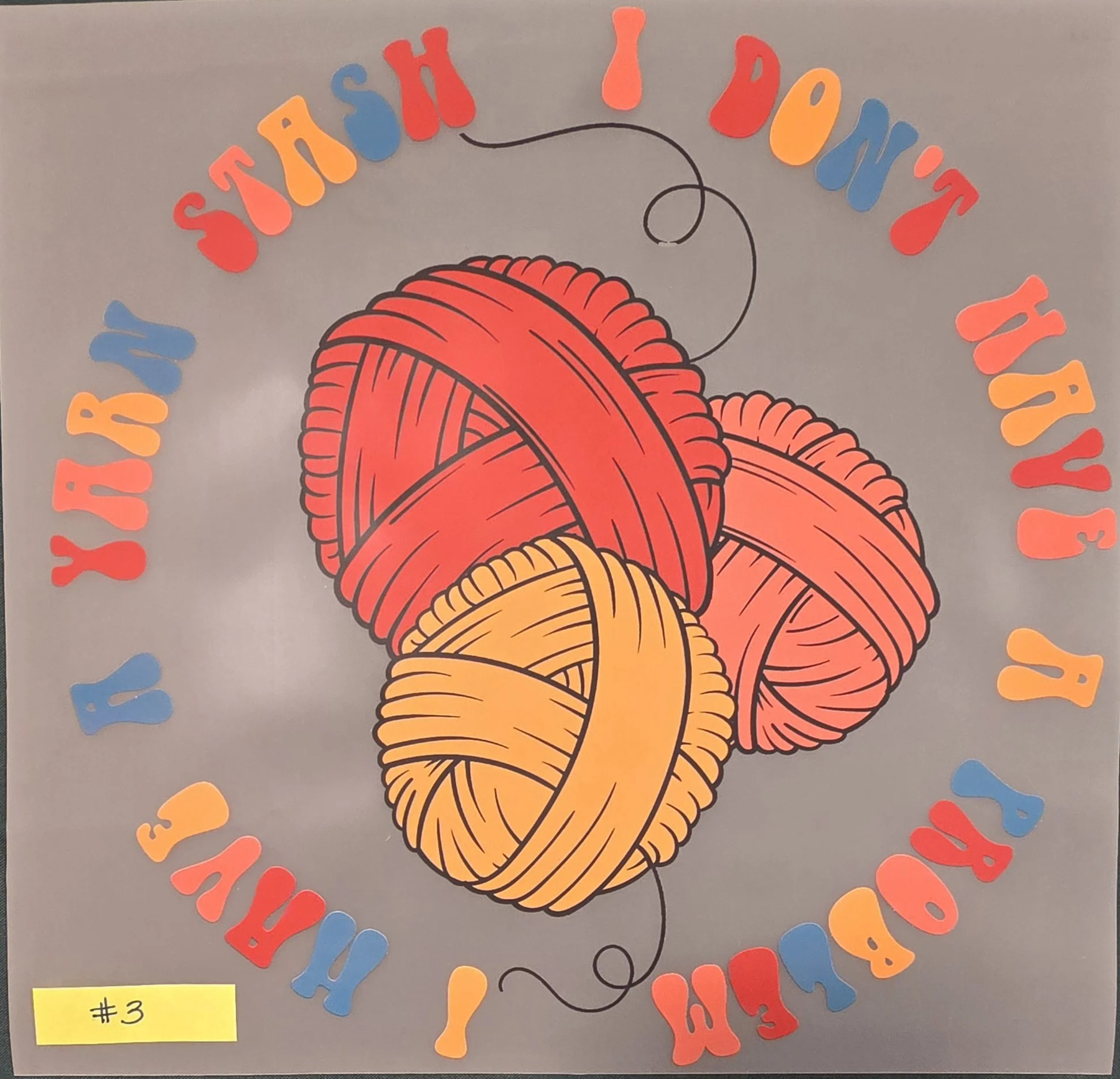 A colorful bulletin board display with paper yarn balls and the words "Yarn-tastic!" in multicolored letters arranged in a circle around a large ball of yarn illustration. A yellow sticky note labeled "#3" is in the lower left corner.