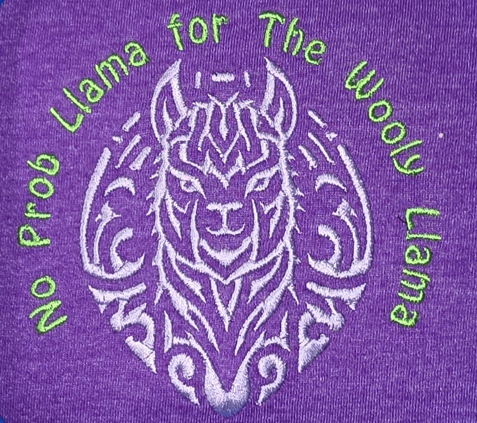 Purple fabric with white and green embroidered design of a Llama face and the text 'No Prob Llama for The Wooly Llama in green.