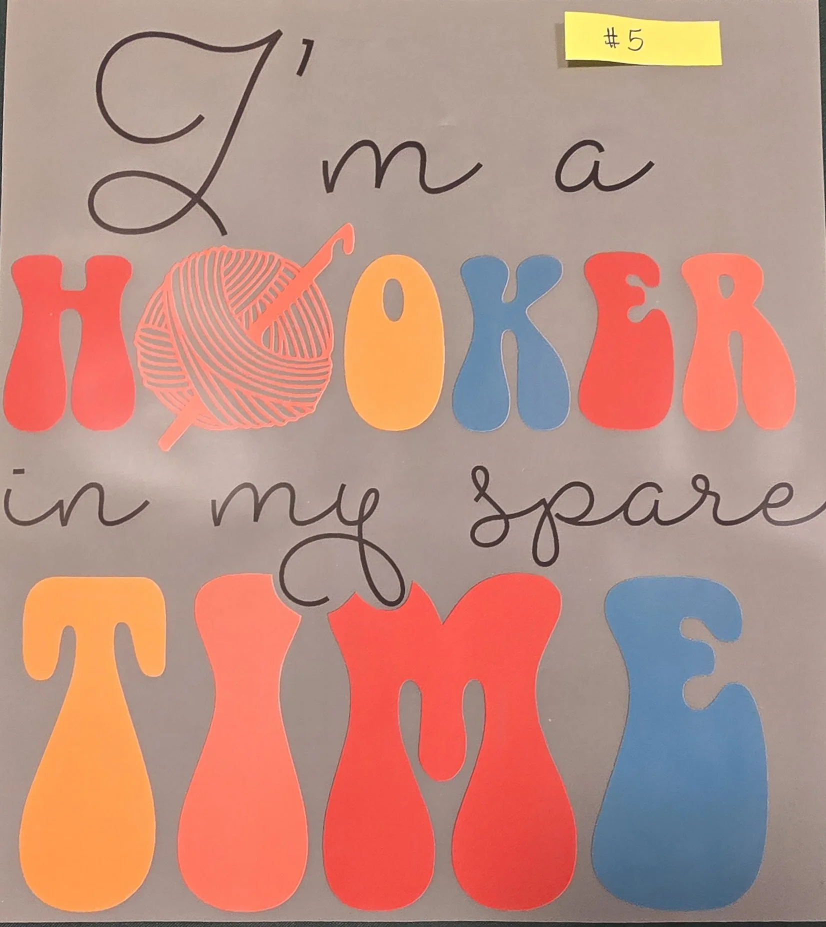Colorful paper cutouts of the phrase "I love my teacher" with the word "love" represented by an orange ball of yarn and a knitting needle, and a yellow, blue, red, and orange color theme.