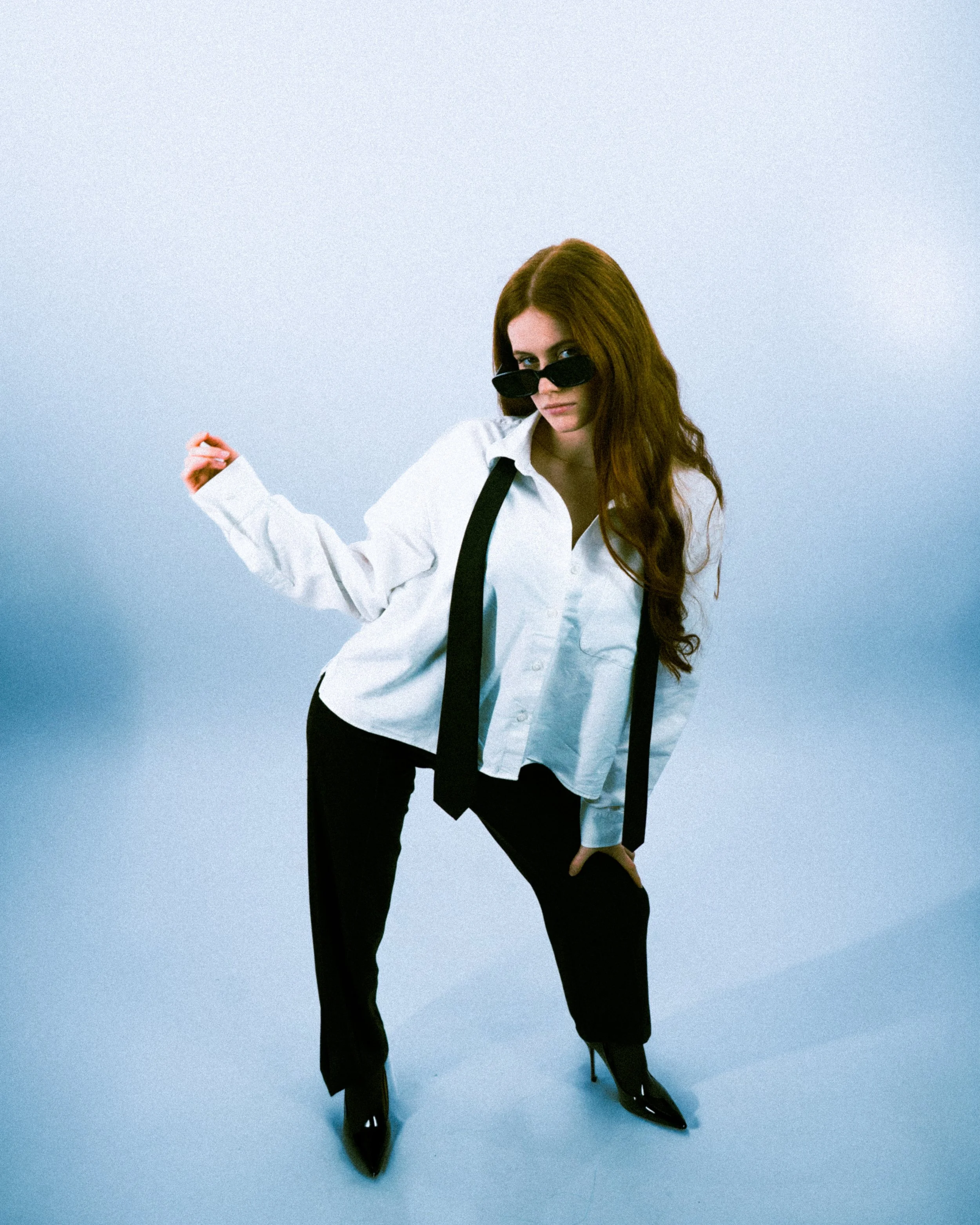 Femme en studio posant avec attitude affirmée, shooting éditorial mode minimaliste.