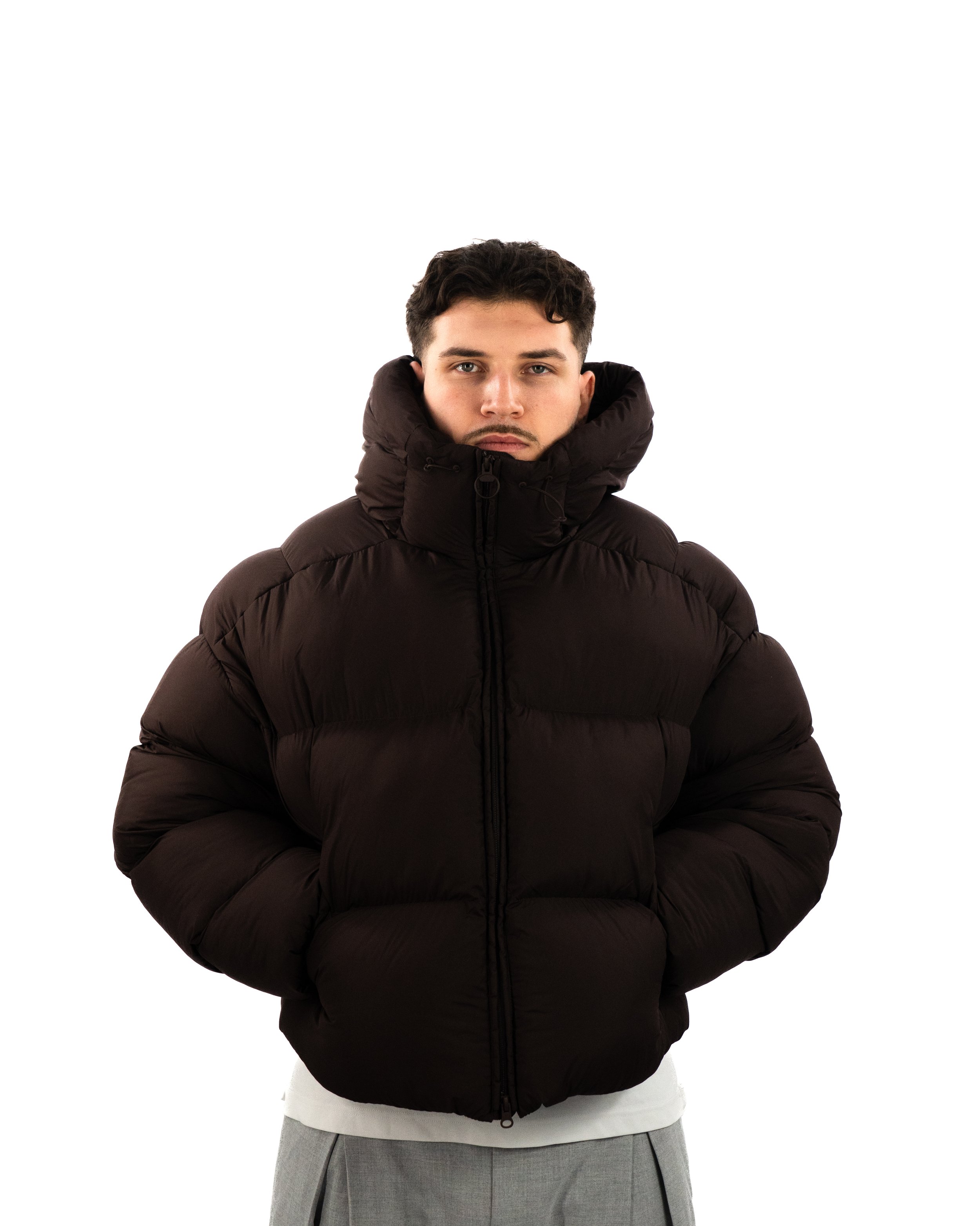 Portrait studio de DJ The Real Fabz en tenue lifestyle, fond blanc minimaliste et photographie promotionnelle.