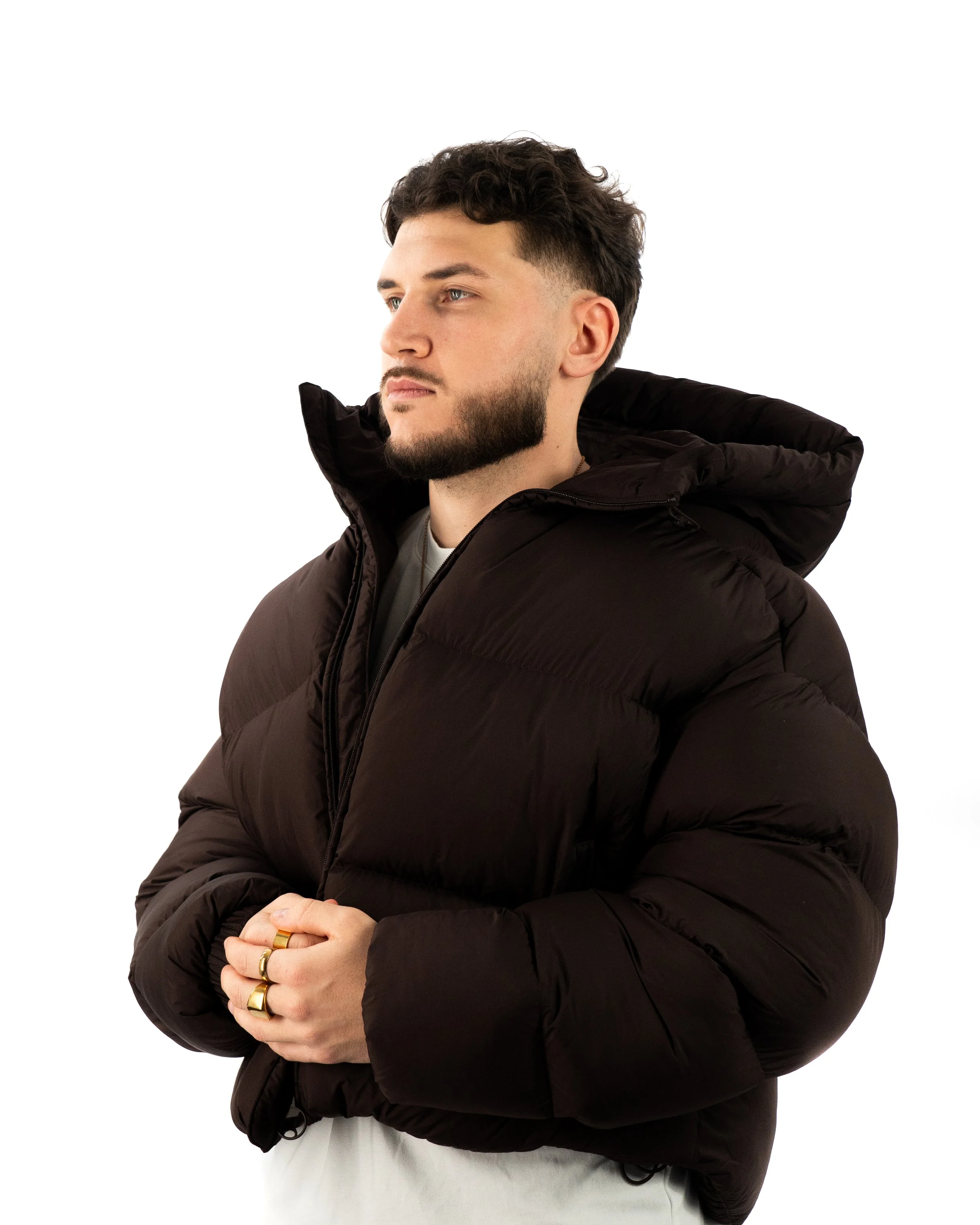 Portrait lifestyle de DJ The Real Fabz en studio fond blanc, attitude élégante et minimaliste.