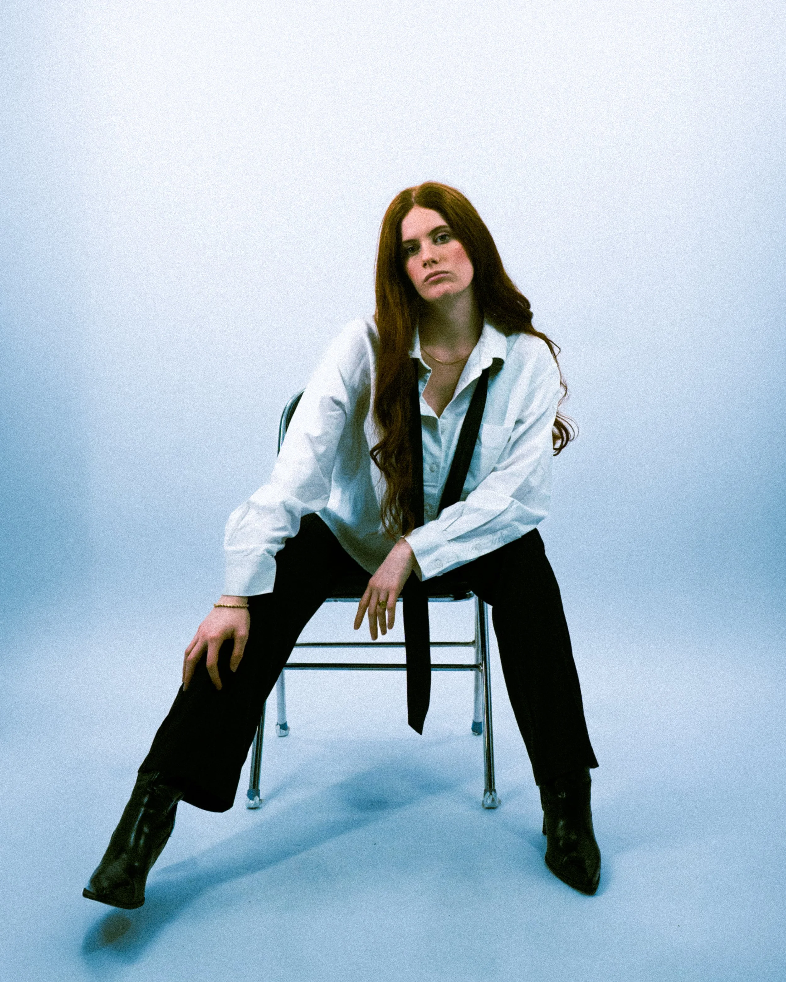 Femme assise en studio posture forte et élégante, photographie éditoriale contemporaine.