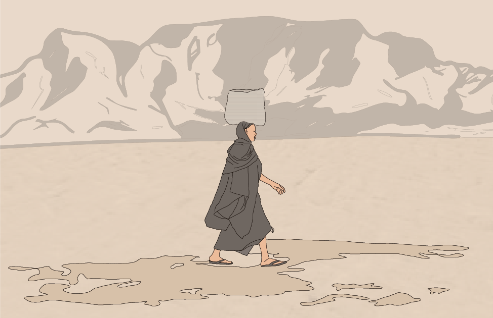 A person dressed in a dark robe and sandals walking in a desert with mountains in the background and a carrier on their head.
