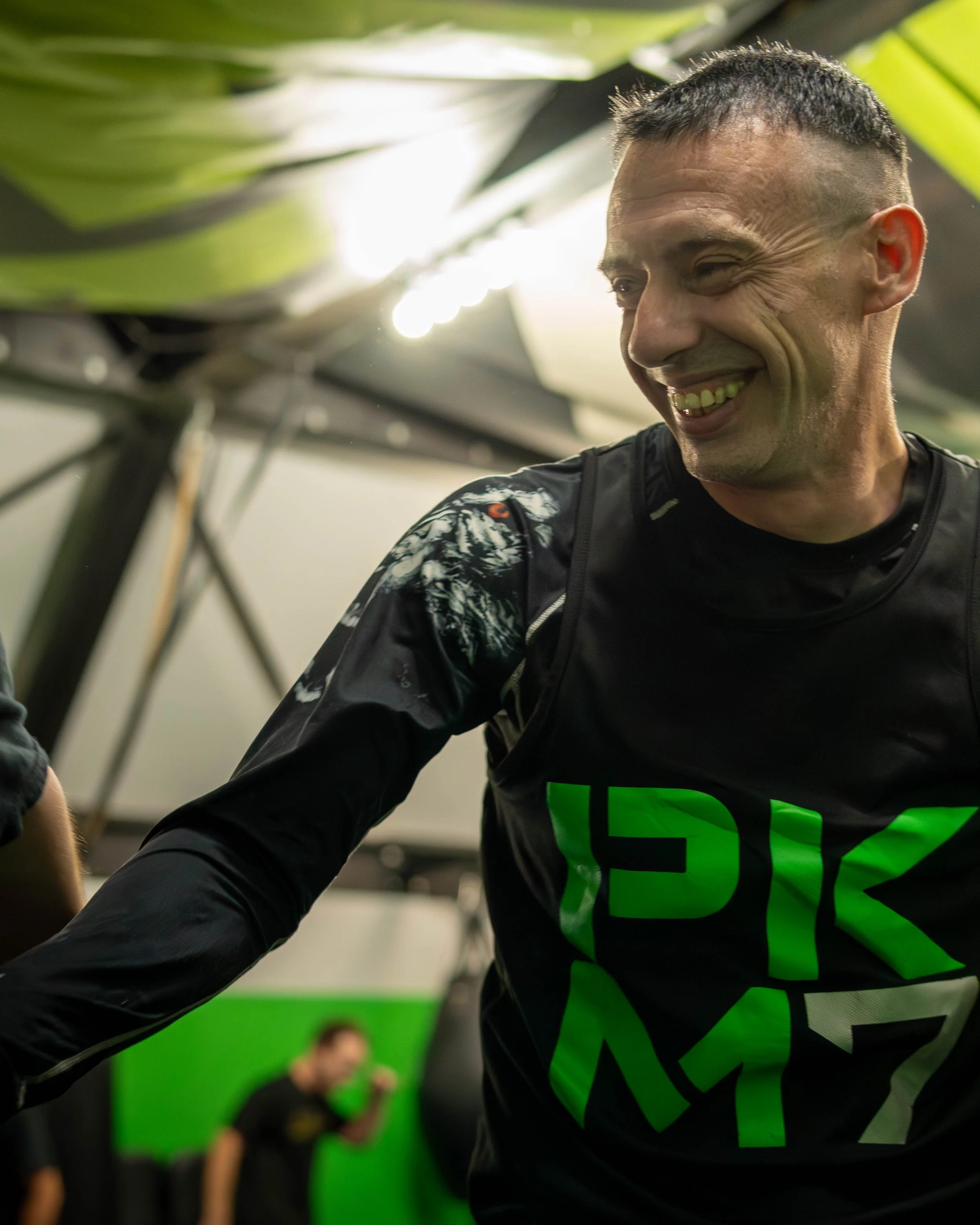 Man smiling wearing PKM7 shirt