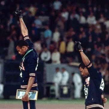 Tommie Smith and John Carlos protesting with fists raised at the 1968 Olympics.