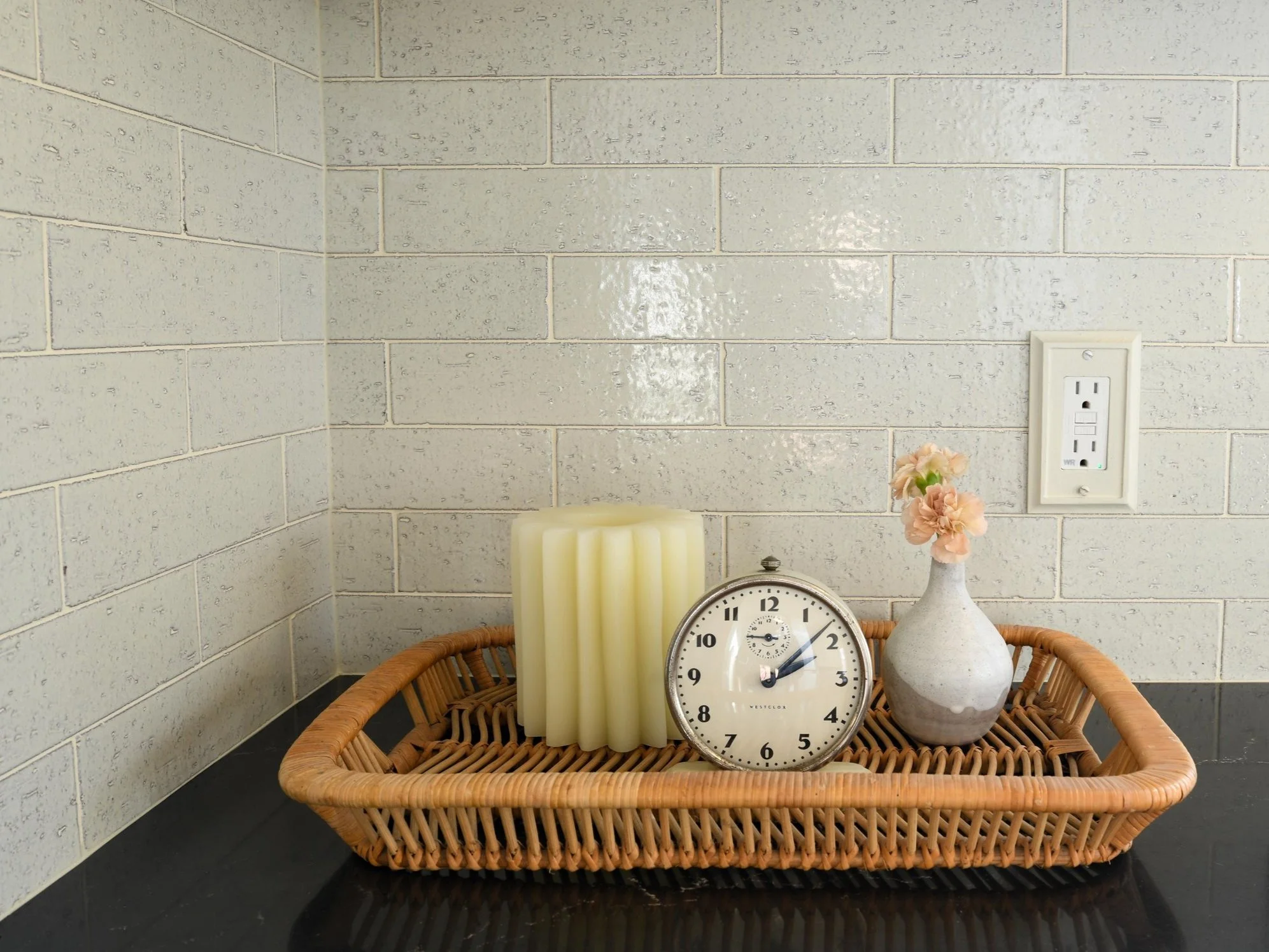 Basket of items in front of a white subway tile backsplash in a newly renovated kitchen in St. Paul