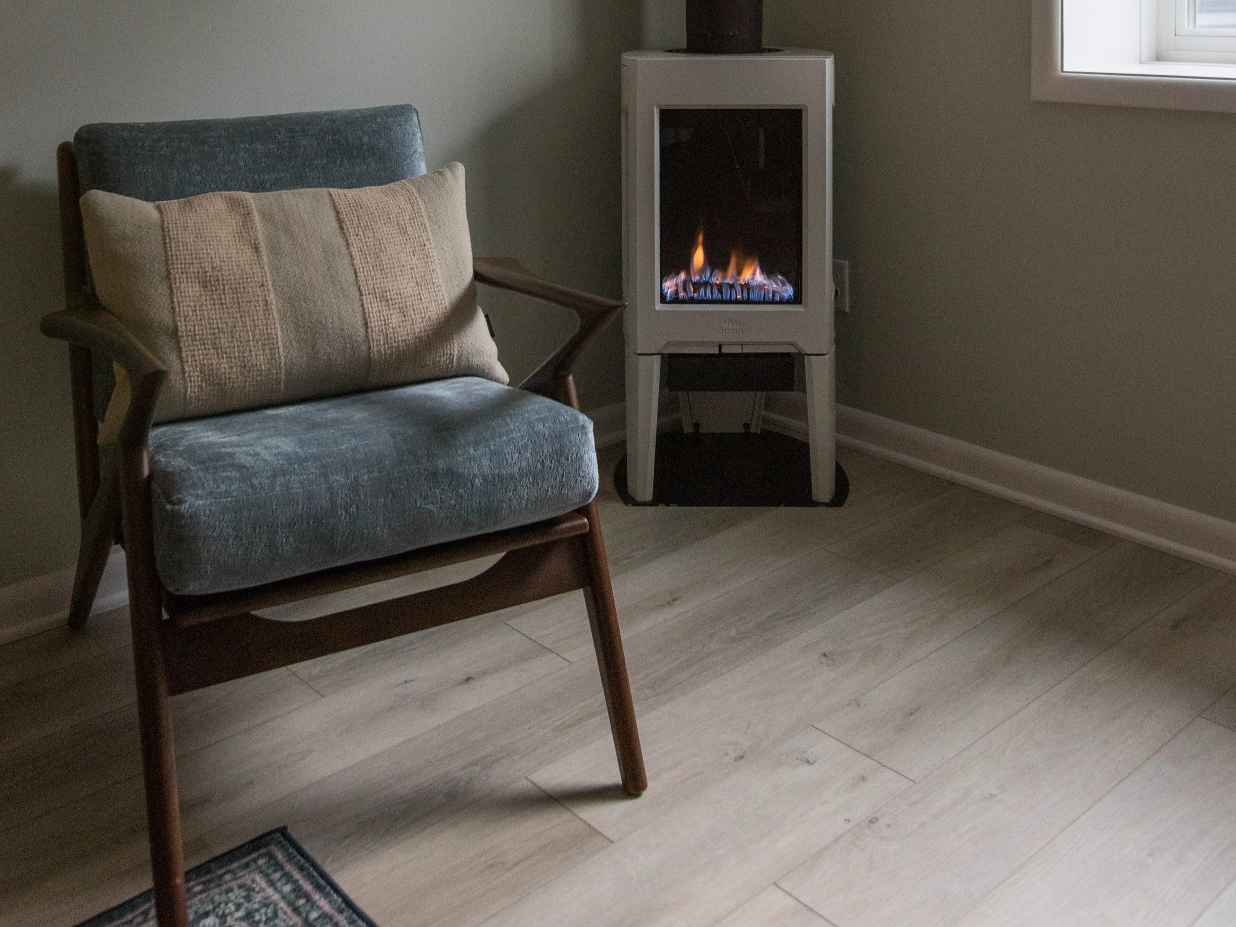 Basement renovation photo featuring a modern chair and fireplace in Minneapolis