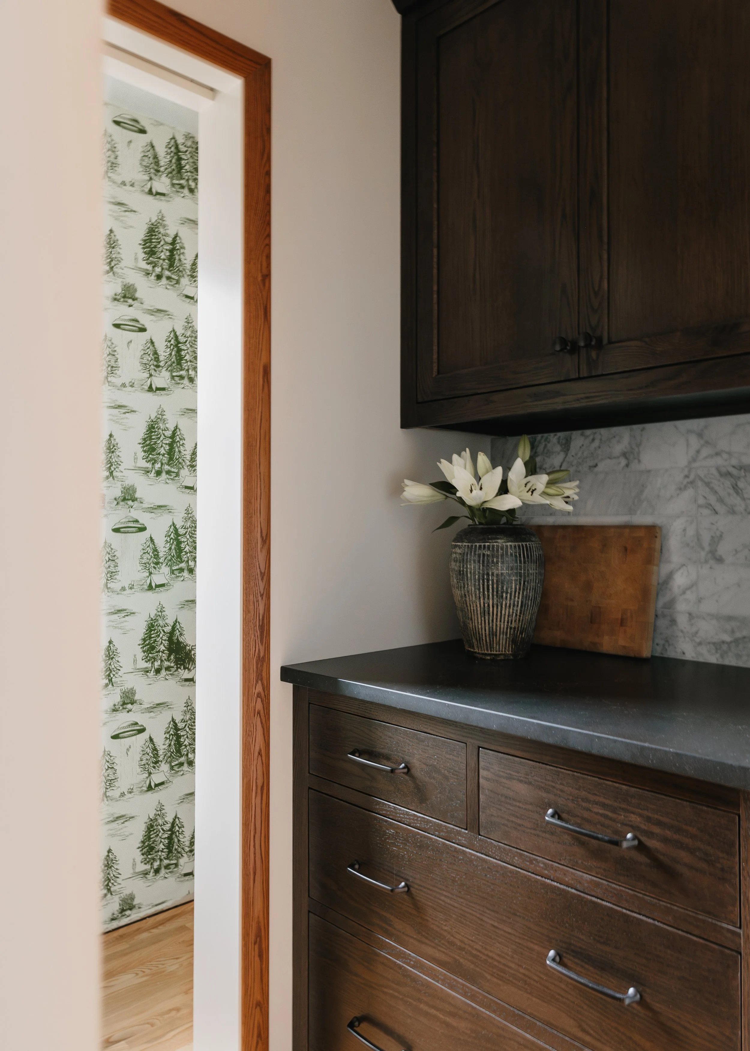 Transitional kitchen with brown cabinets, dark countertops, and wood accents in Twin Cities renovation