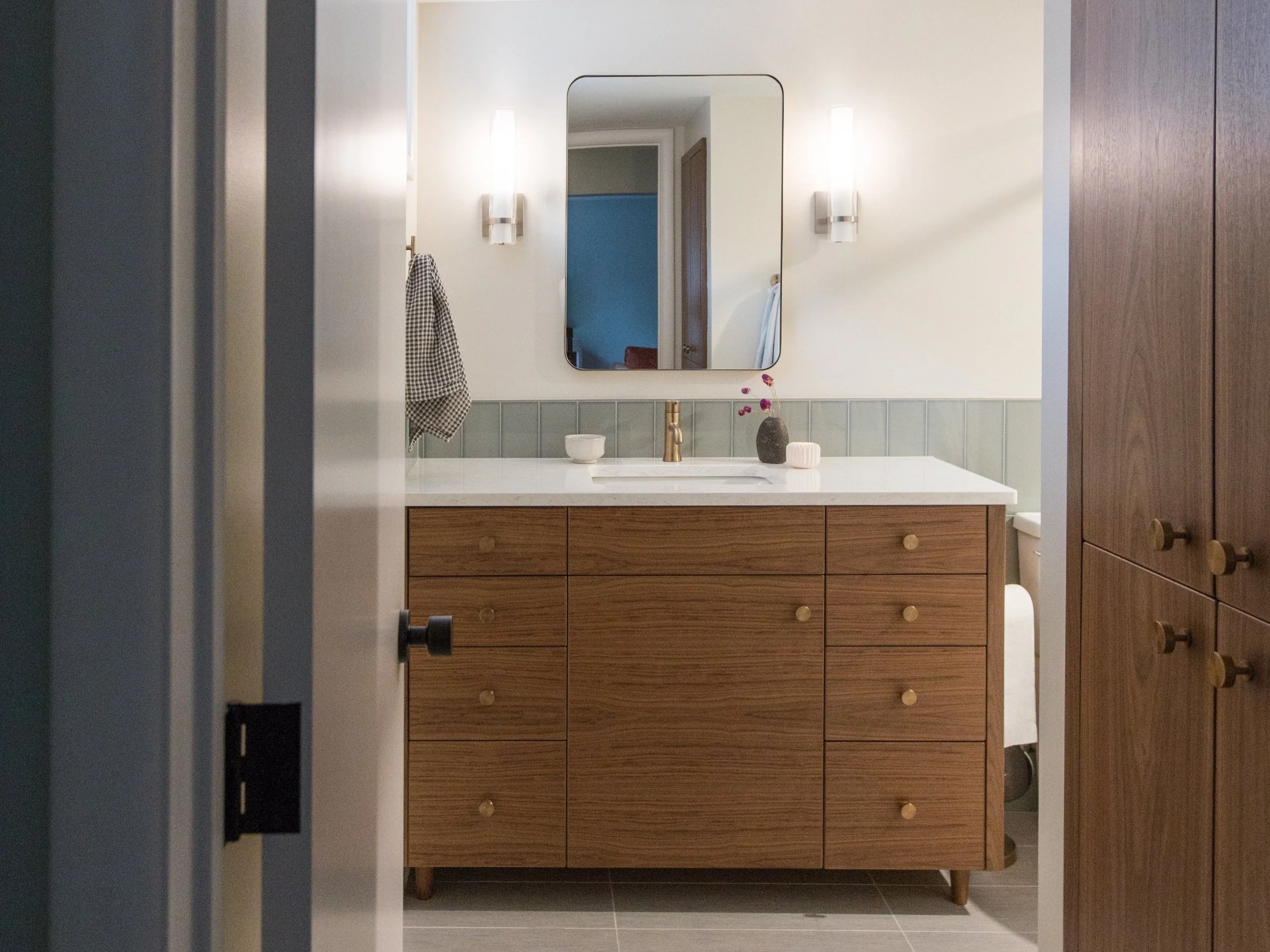 Bathroom renovation by PrinceWorks and Seth Prince in Minneapolis, featuring a wooden vanity with high-quality counter and a wall of built-in bathroom storage.