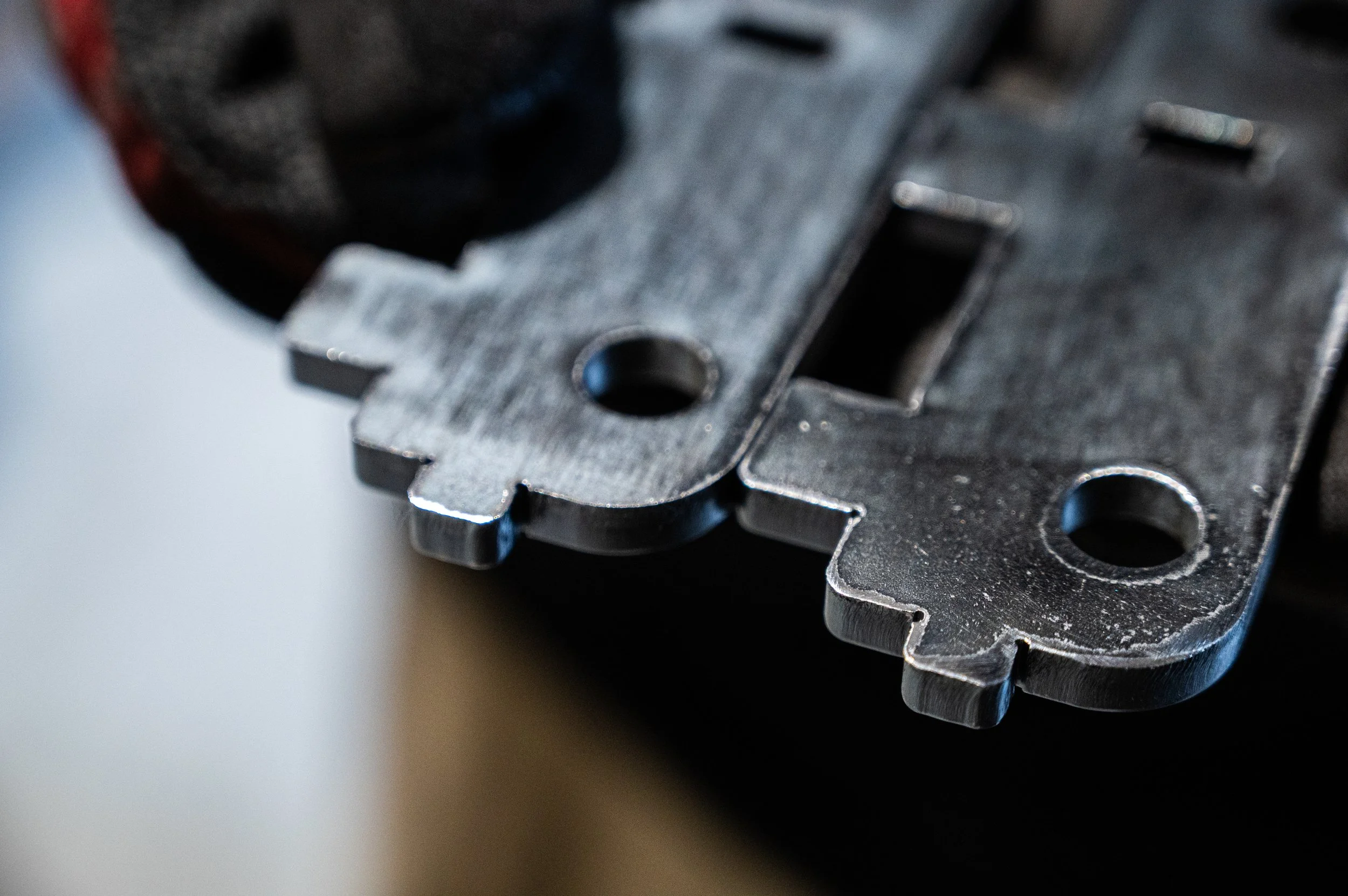 Close-up of a metal machine part with holes and notches
