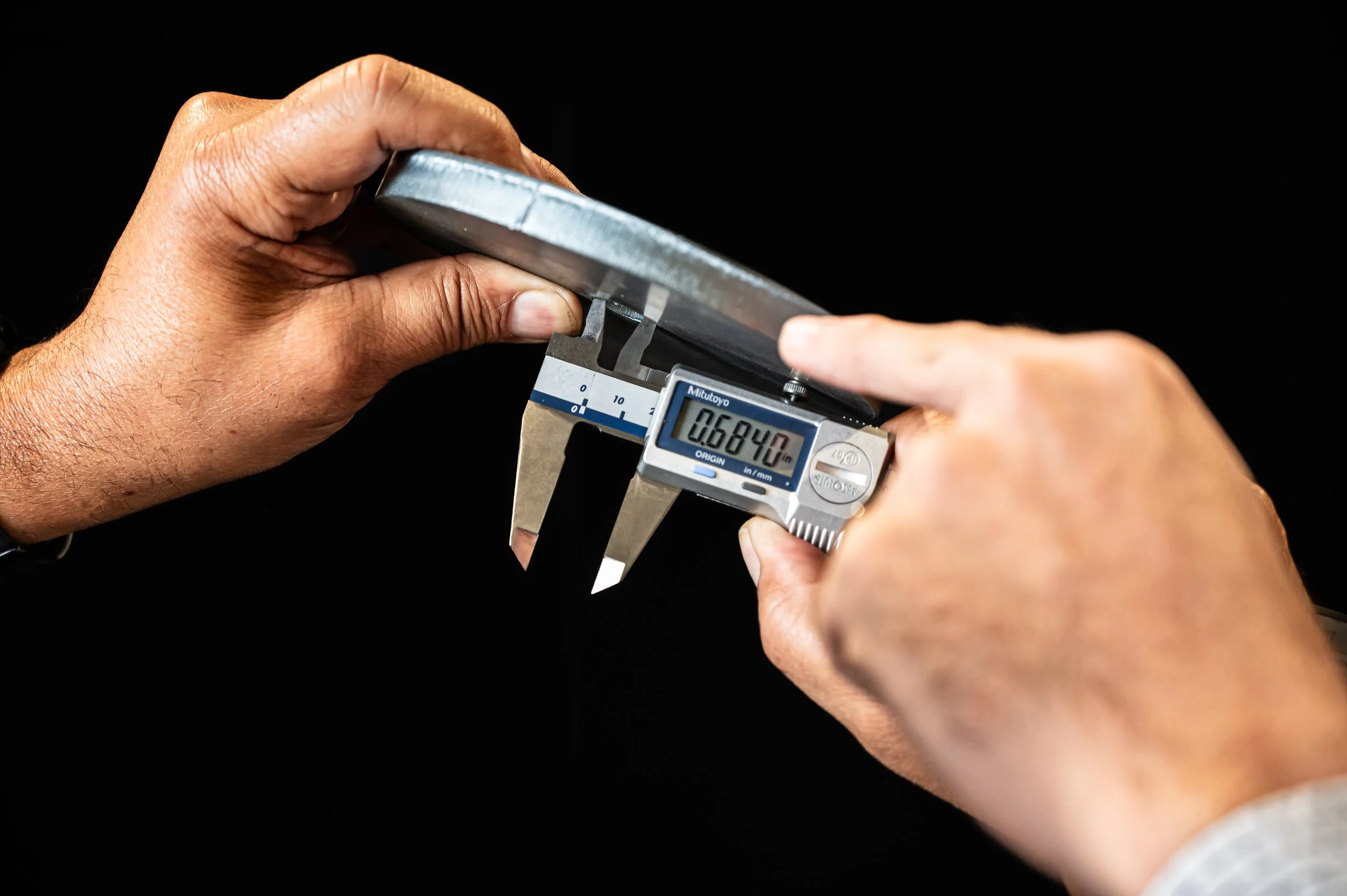 Using a digital caliper to measure the thickness of a metal parts