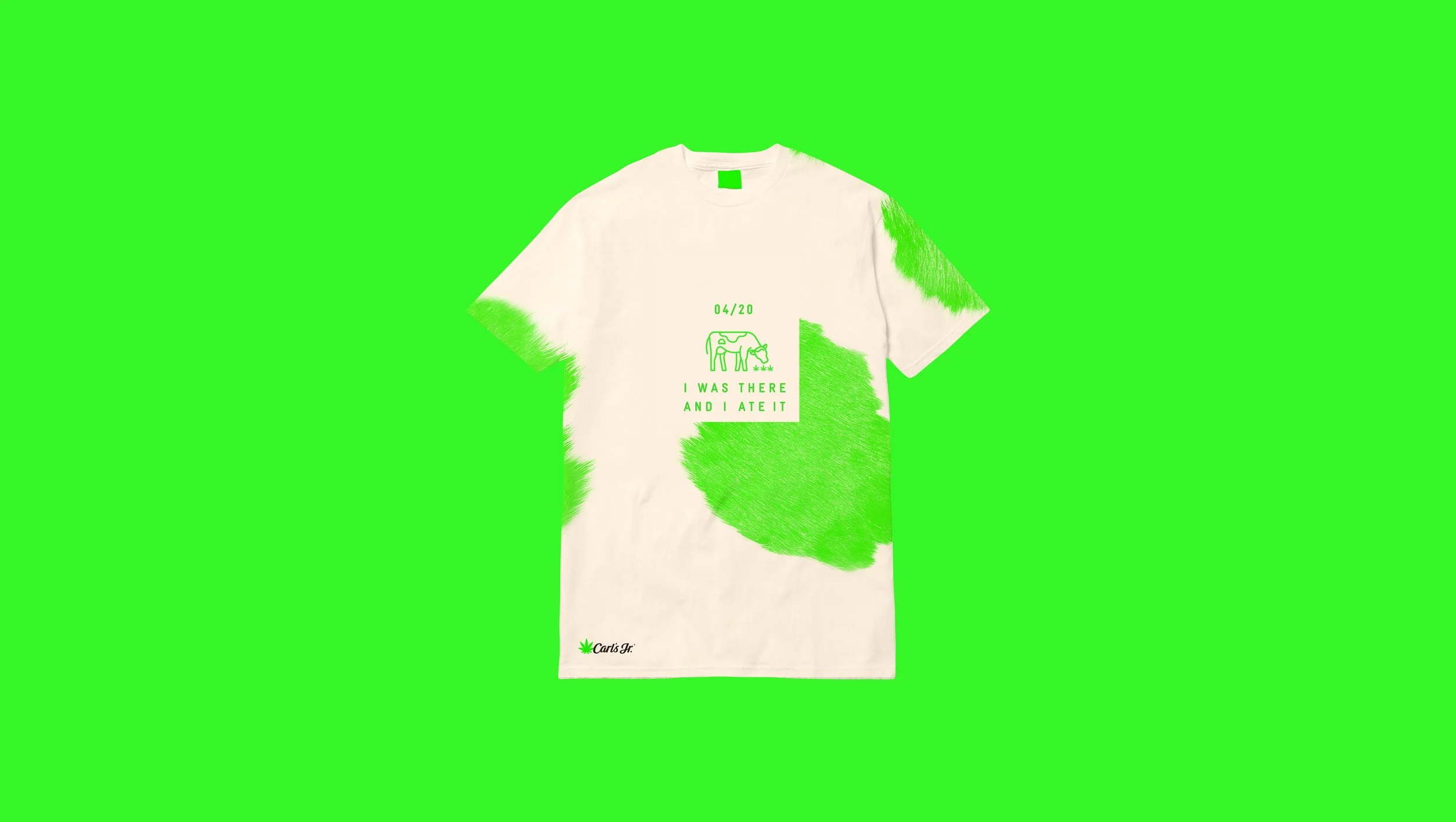 White T-shirt with green paint splatter design, a small graphic of a cow and a book, the text '04/20', and the phrase 'I WAS THERE AND I ATE IT'. Green background.
