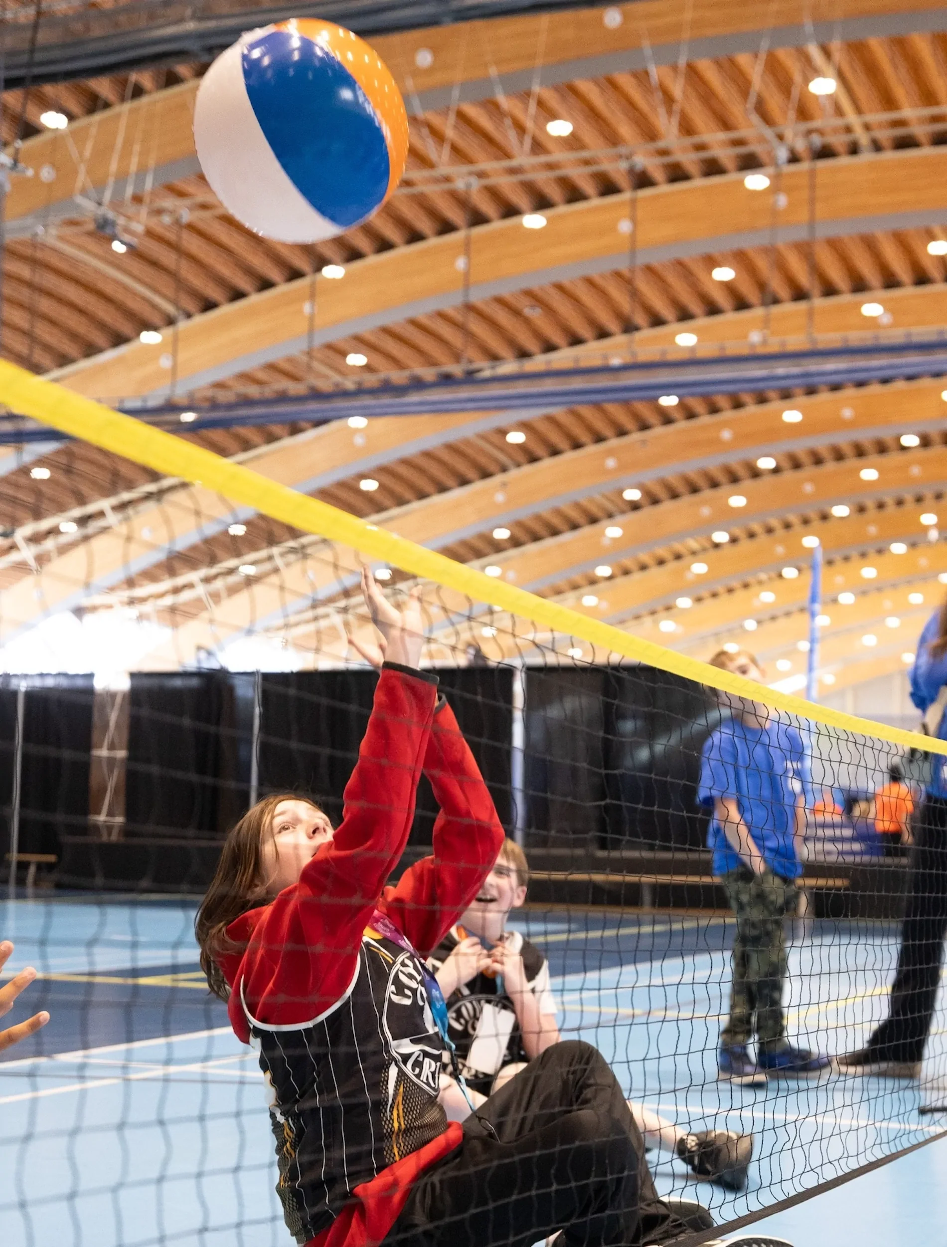 Student playing sitting volleyball with a beachball