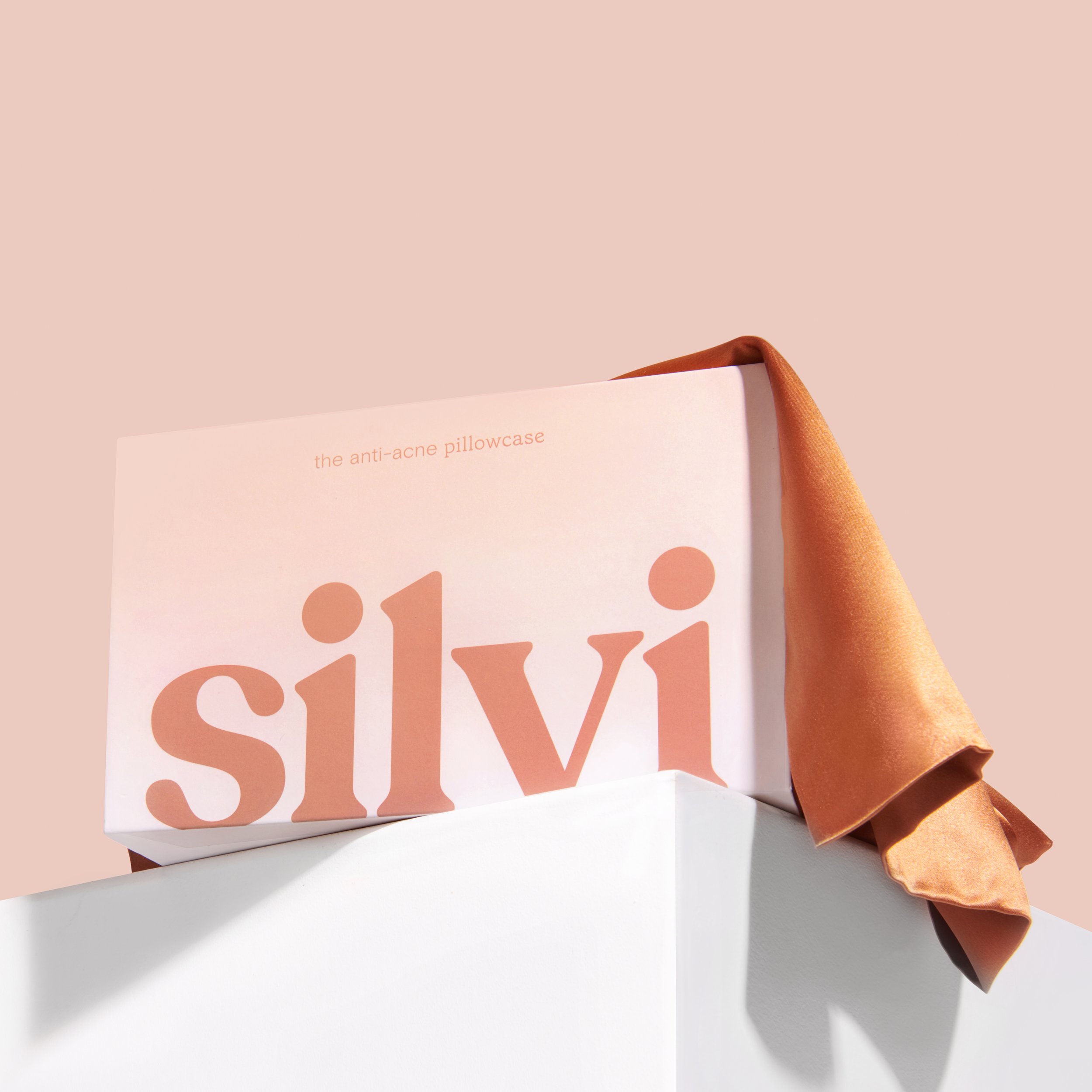 Silvi anti-acne pillowcase box with orange cover on white pedestal
