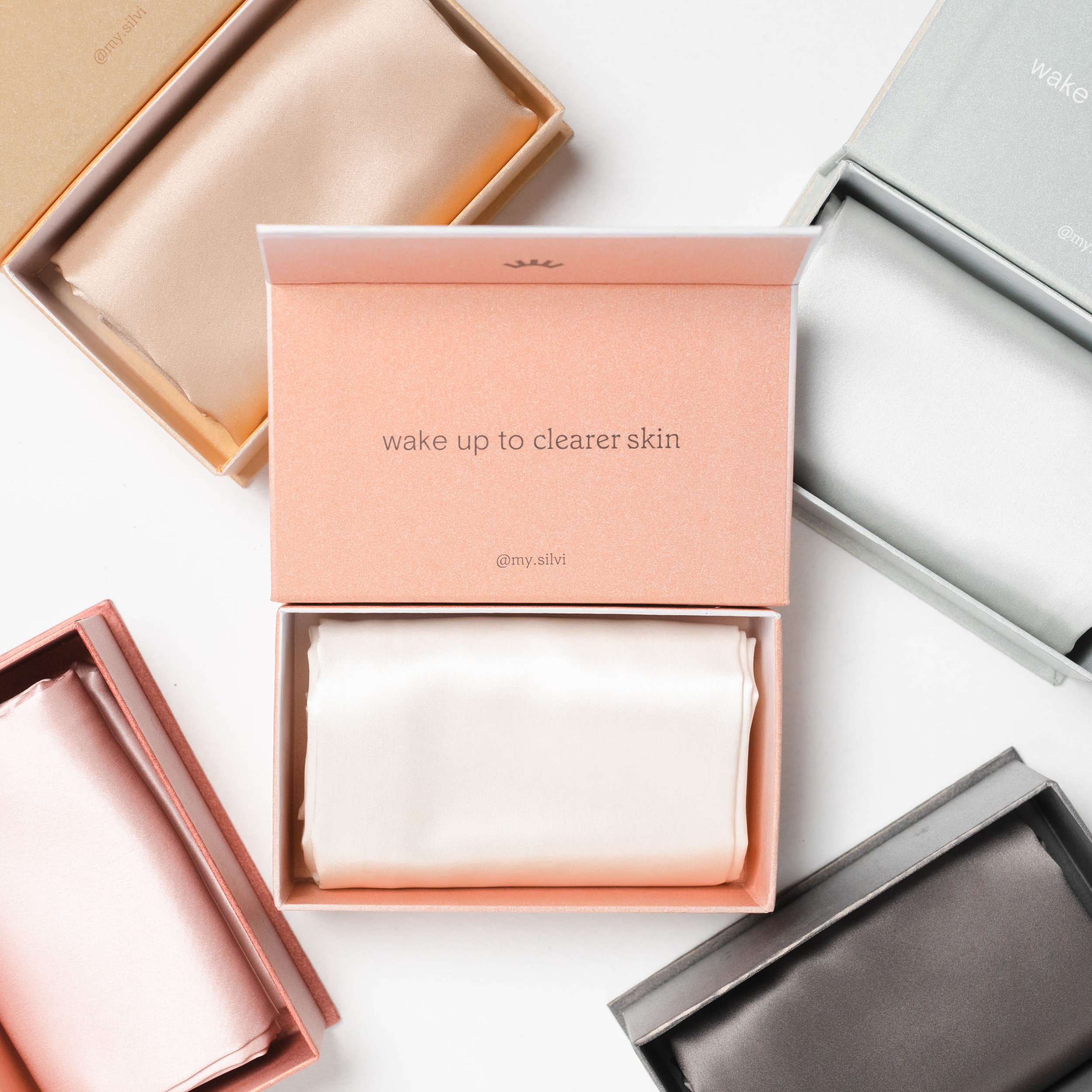Silk pillowcases in boxes with 'wake up to clearer skin' message displayed.