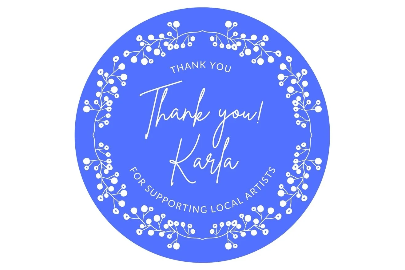 A blue circular thank you sticker with white decorative berries border, featuring a message that reads: "Thank you! Karla for supporting local artists."