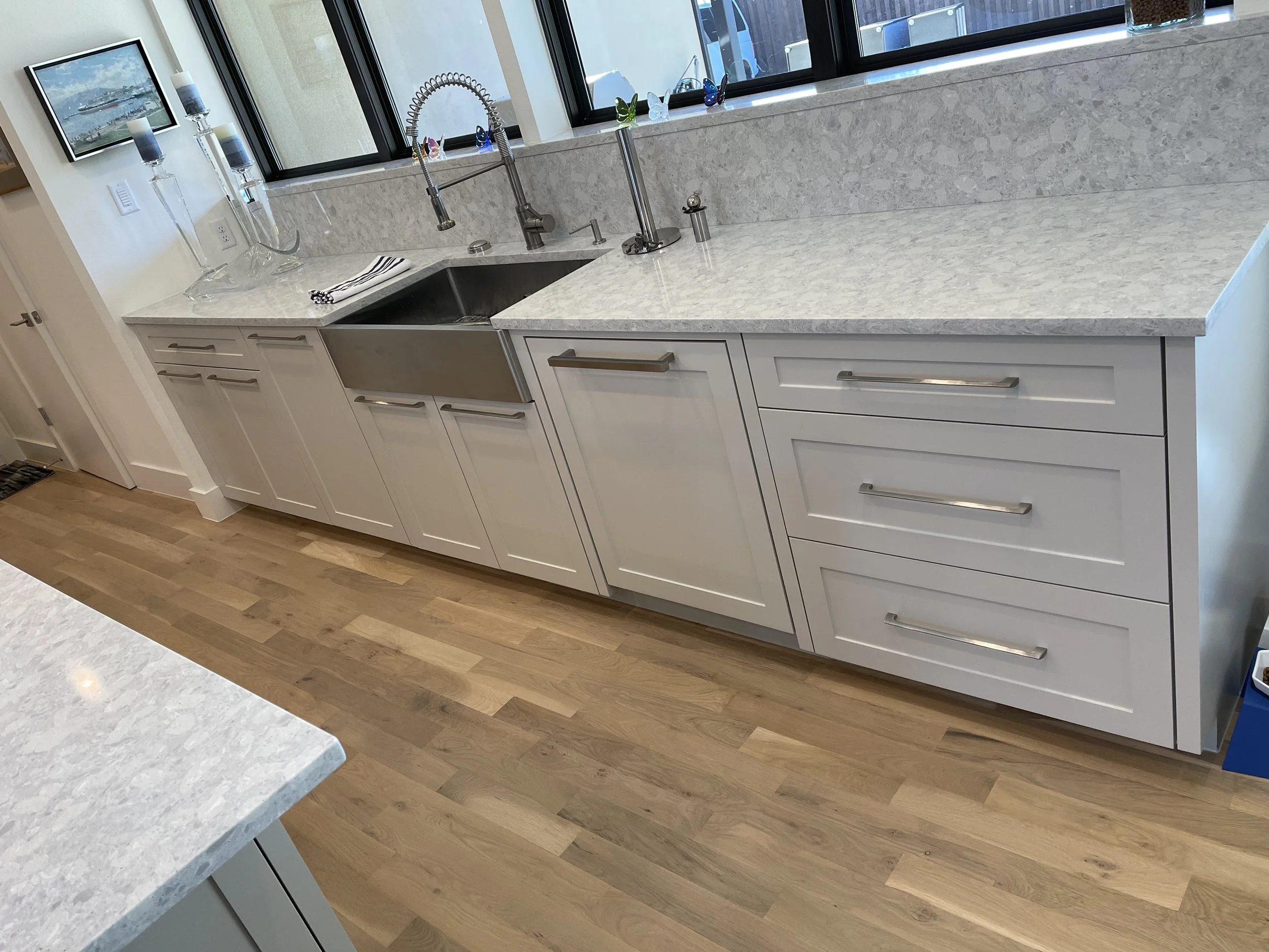 Modern bathroom with double sink vanity, large mirror, and walk-in shower, adjacent to a bedroom with a bed and nightstand.