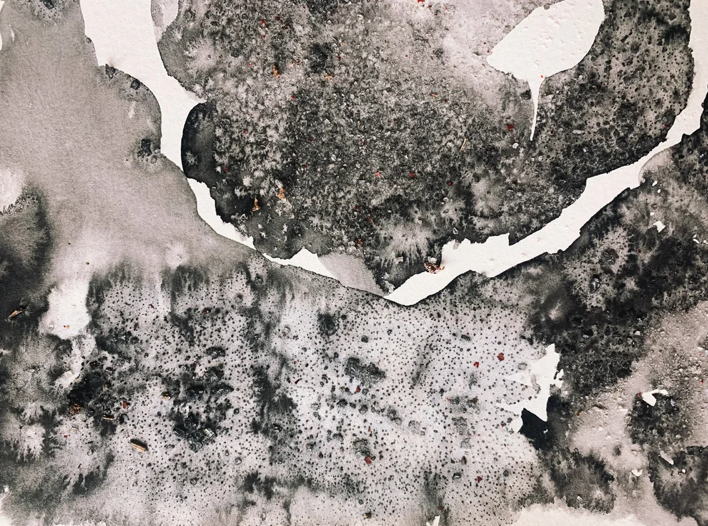 Abstract black and white watercolor splashes and textures with uneven edges.