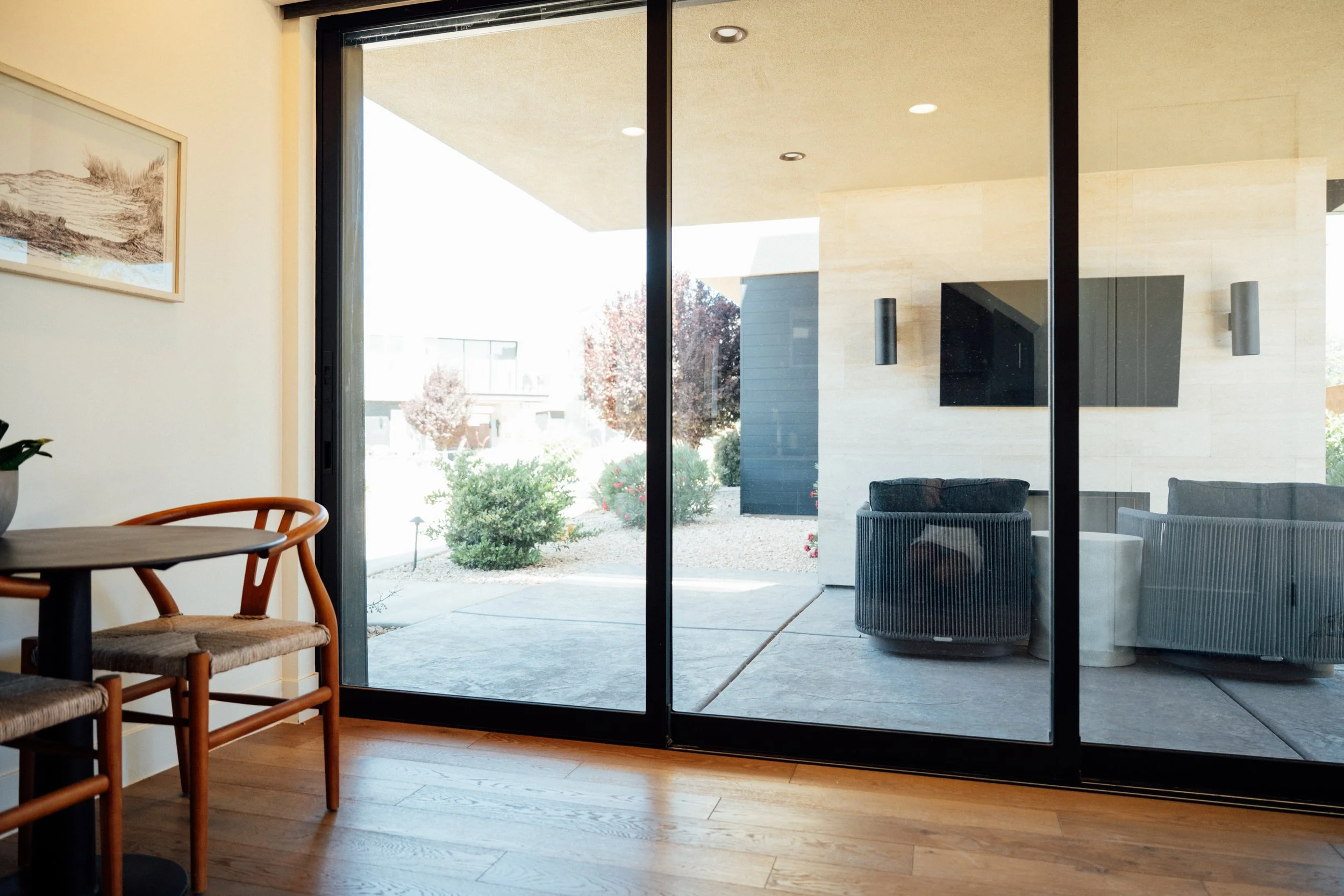 Movara Kitchen and dining area looking outside to the outdoor patio with chairs and tv. 