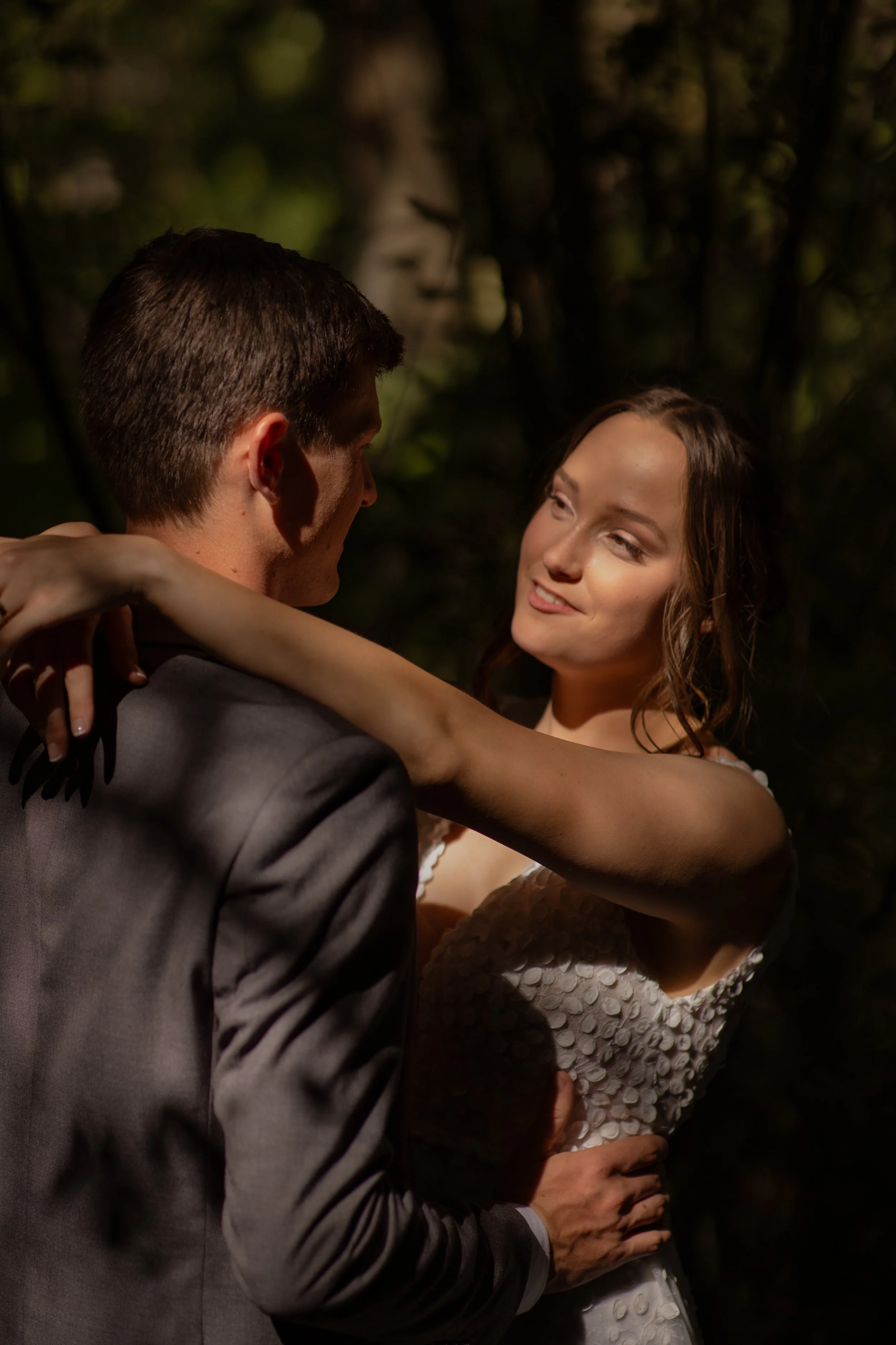A man and woman dancing outdoors at night, with the woman smiling and looking at the man, who is facing away from the camera.  Wedding Photography Waikato New Zealand. Wedding Photography Hamilton New Zealand. Northland Wedding Photography