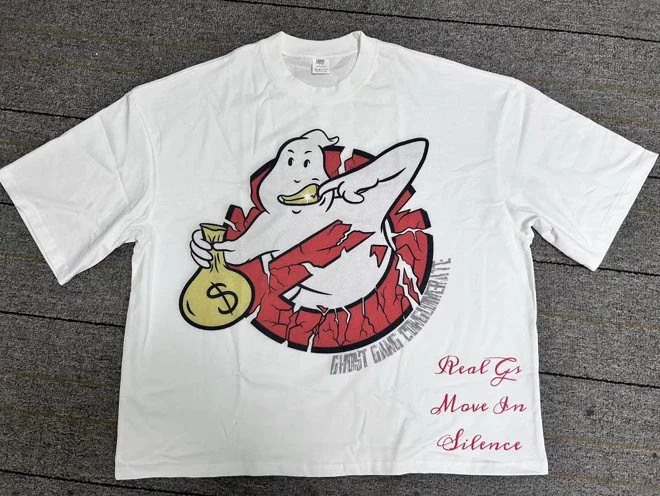 White t-shirt featuring a cartoon ghost logo with a money bag in its hand. The text "Ghost Gang Enterprises" appears around the logo. Red cursive text on the bottom right reads "Real G Move in Silence."