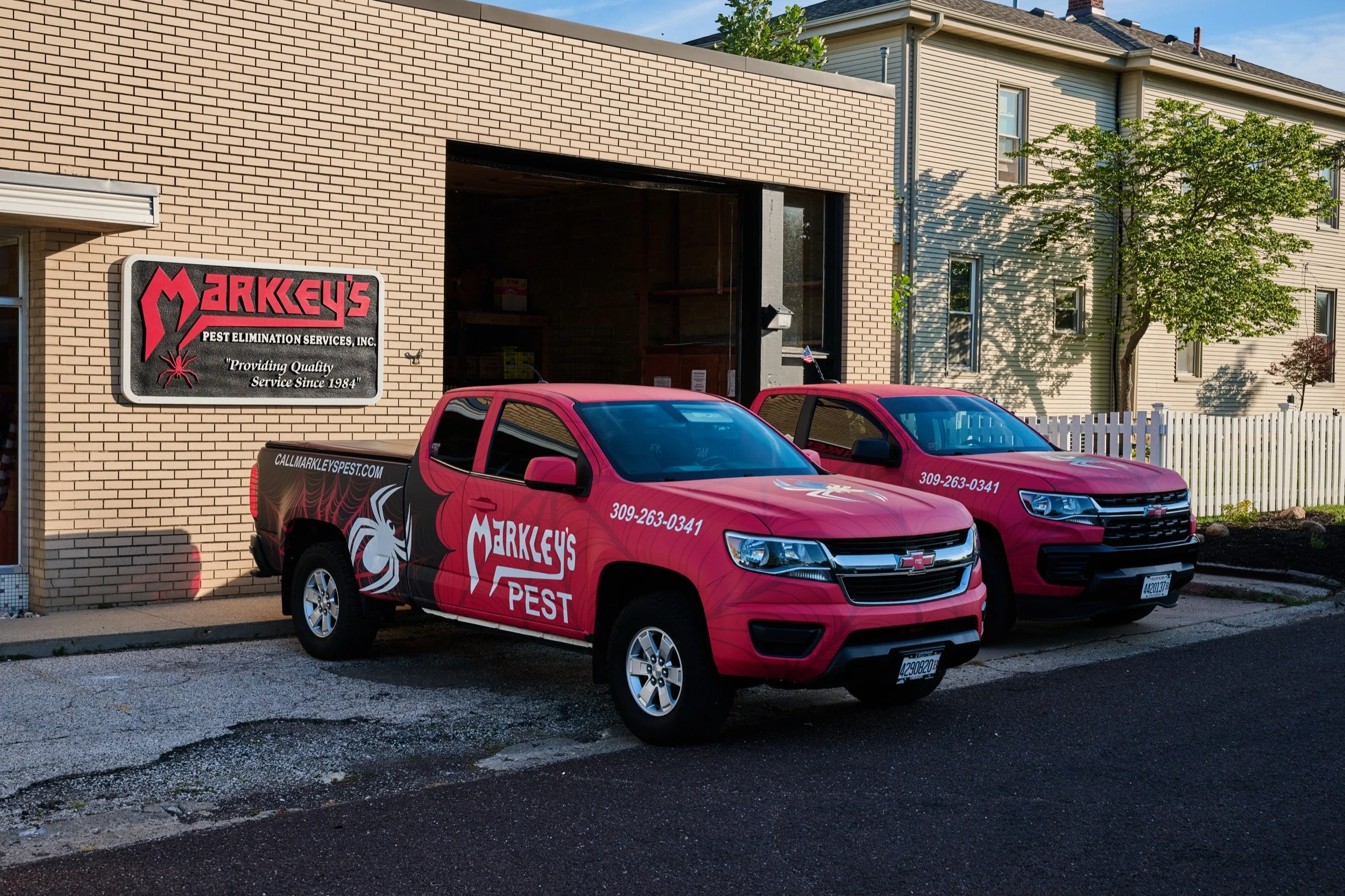 The Markley's Pest Services fleet of branded service trucks lined up outside the shop in Morton, Illinois.