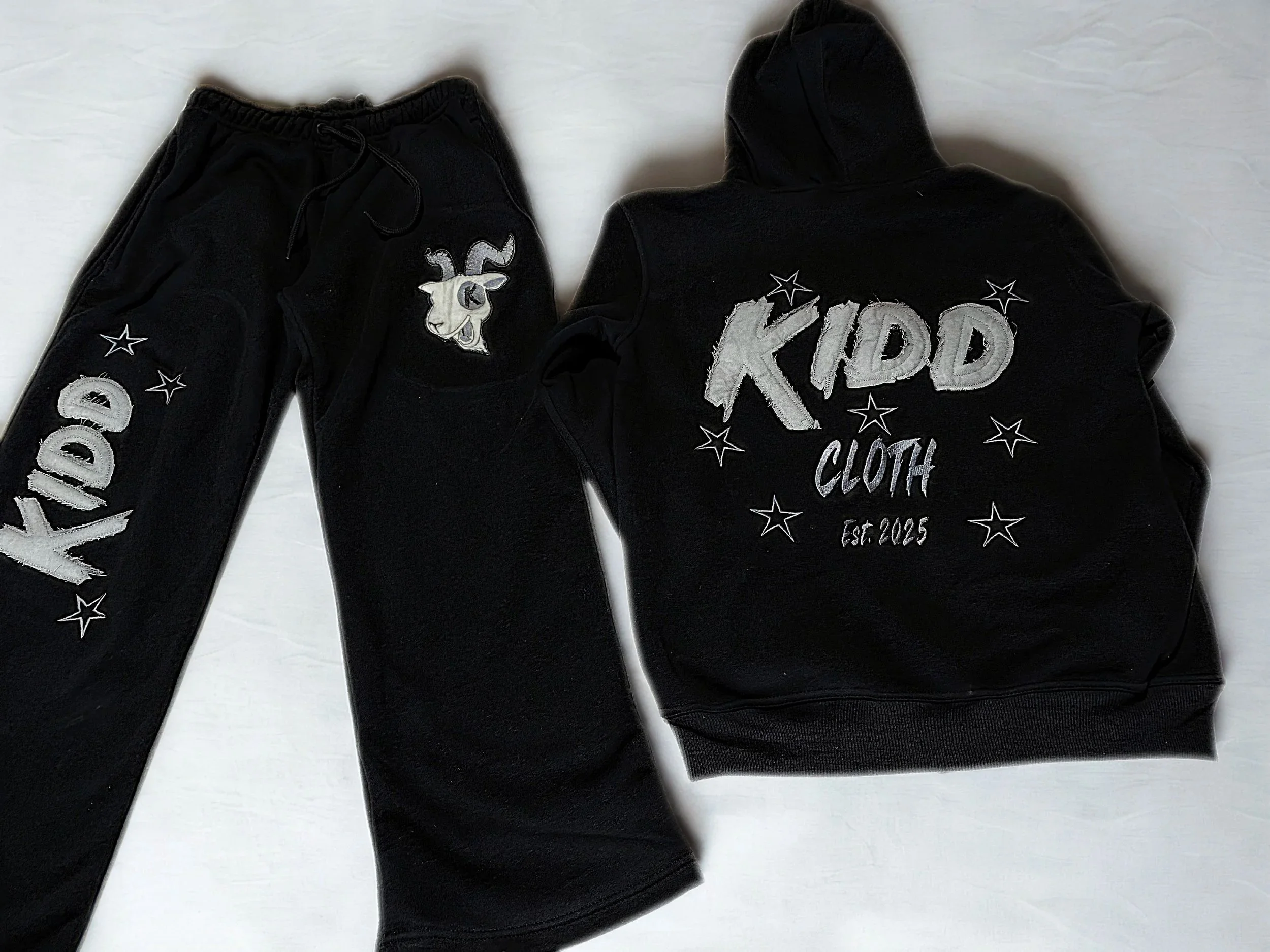 black baggy sweat suit with grey distressed lettering with a white and grey goat head 2025