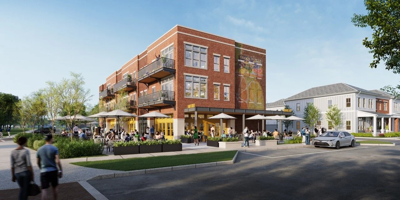People dining outside at a modern urban restaurant with a brick building and upper-level balconies, surrounded by trees and parked cars.