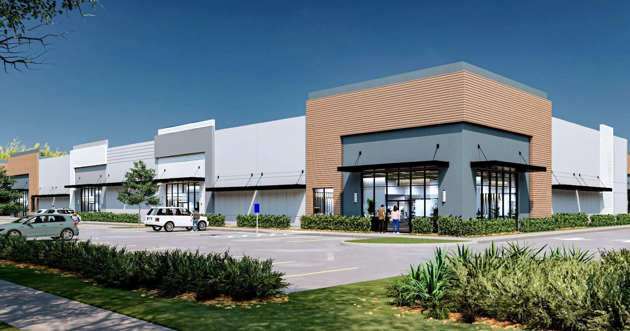 An exterior view of a modern shopping center with multiple storefronts, parking lot, and people walking in and out of stores under a clear blue sky.