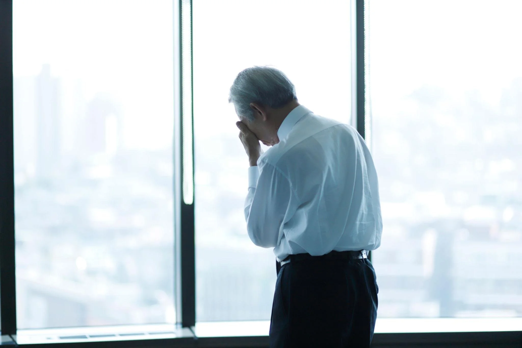 High-performing executive sitting alone in an office while experiencing burnout