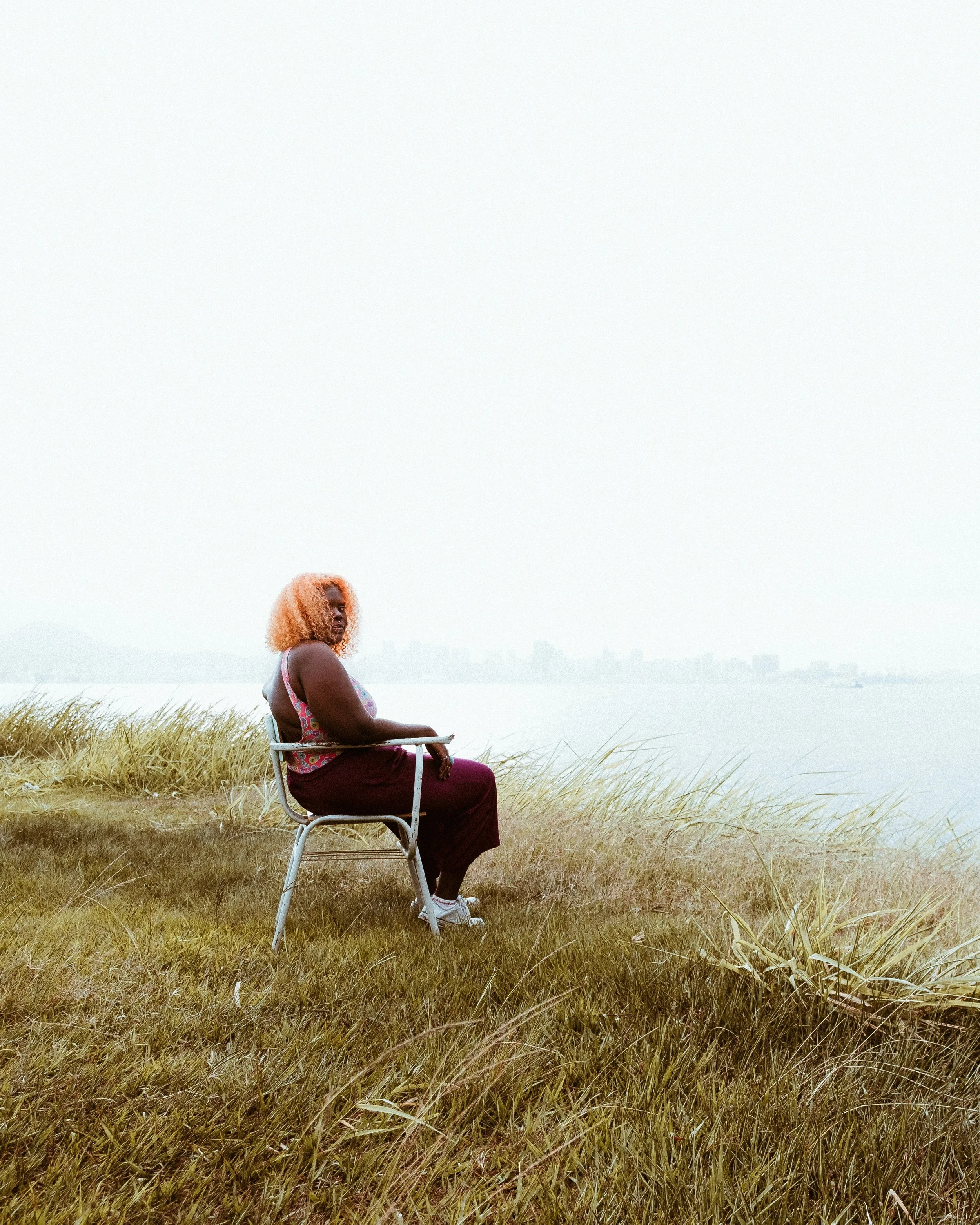 A person sitting in a chair indoors during the day.