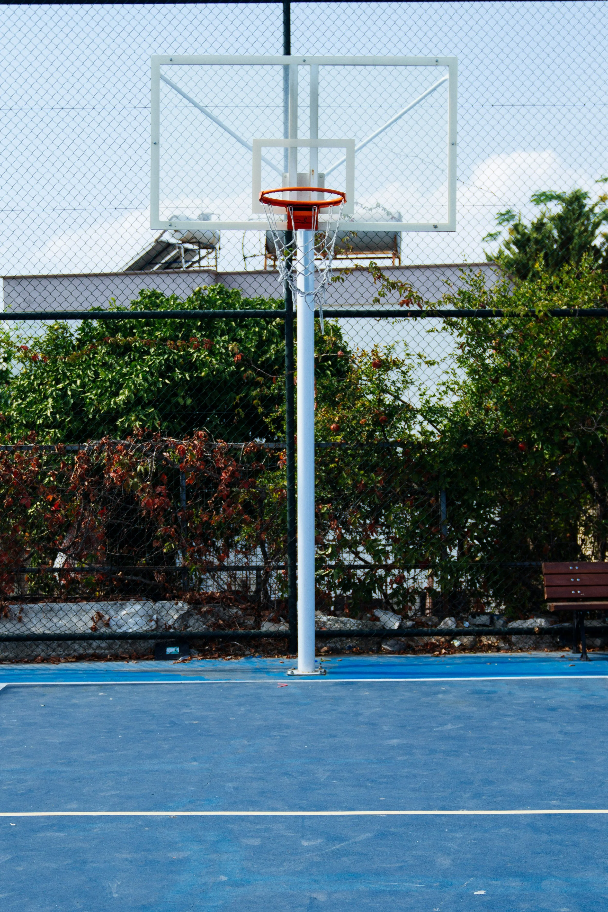 An empty outdoor basketball court in daylight.