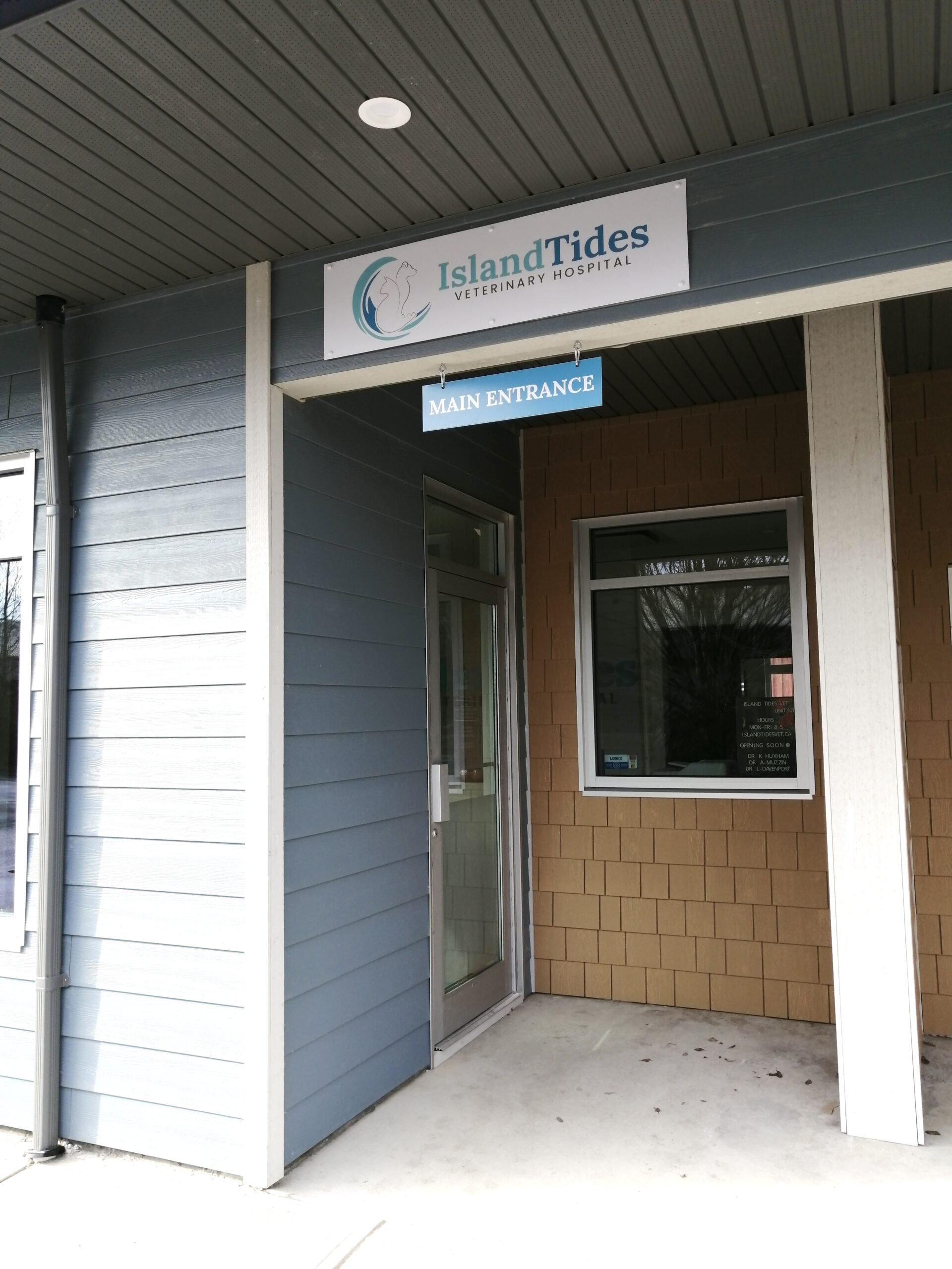 Entrance to Island Tides Veterinary Hospital with a sign above the door indicating it is the main entrance.