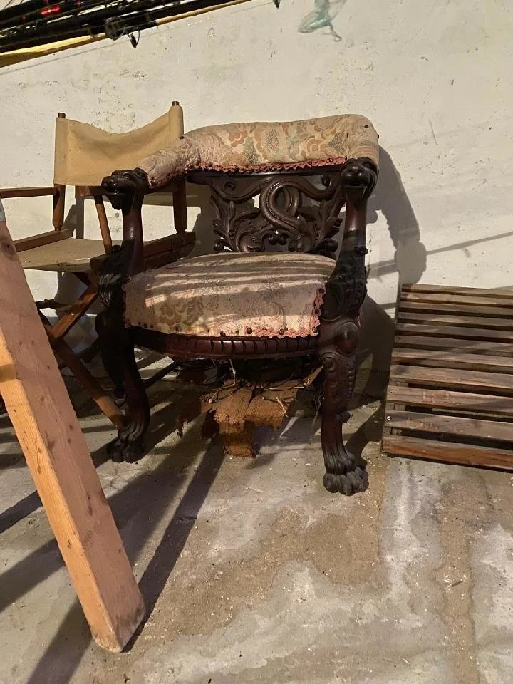 Antique lion chair before reupholstery in disheveled condition