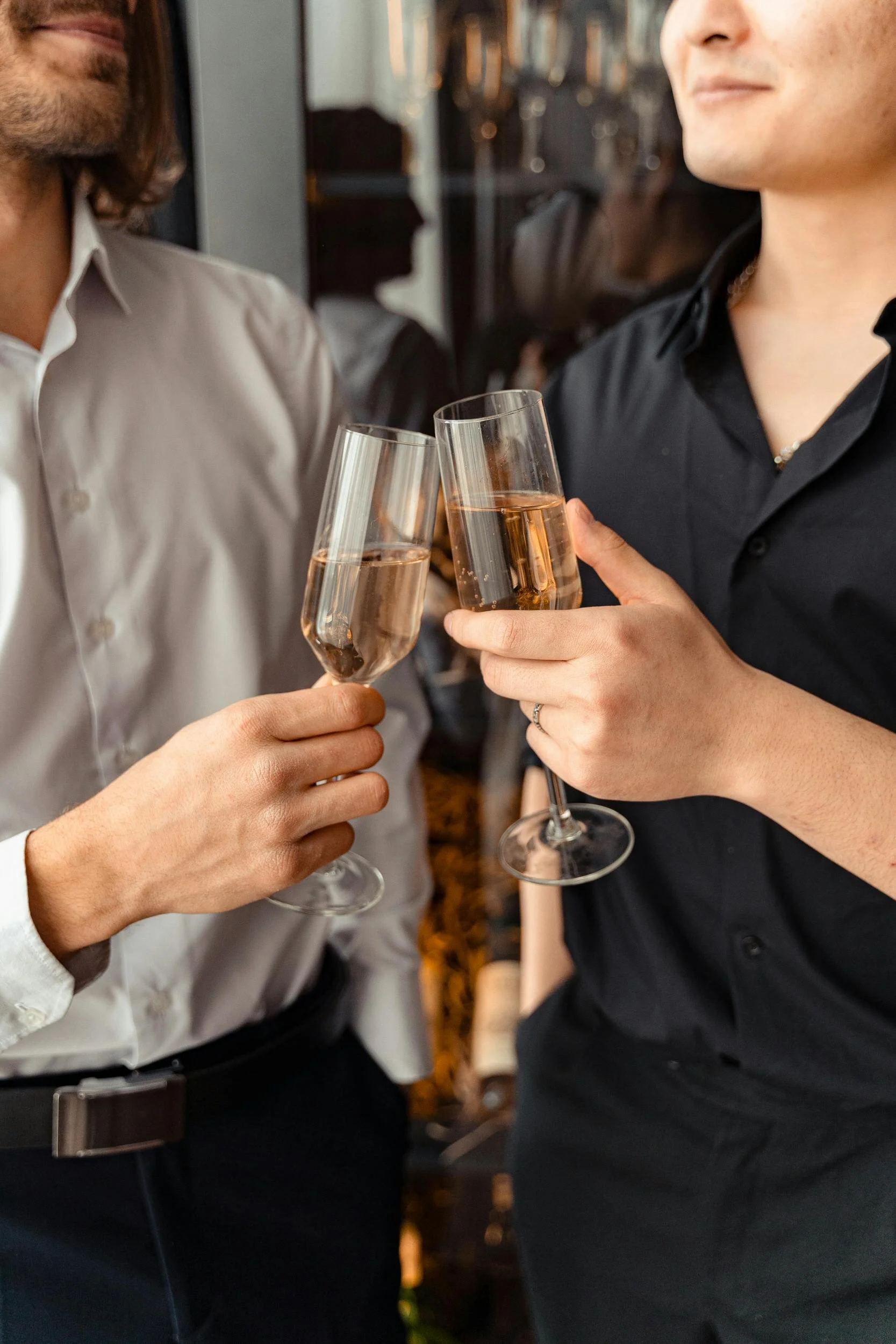 Deux personnes trinquant avec des flûtes de champagne.