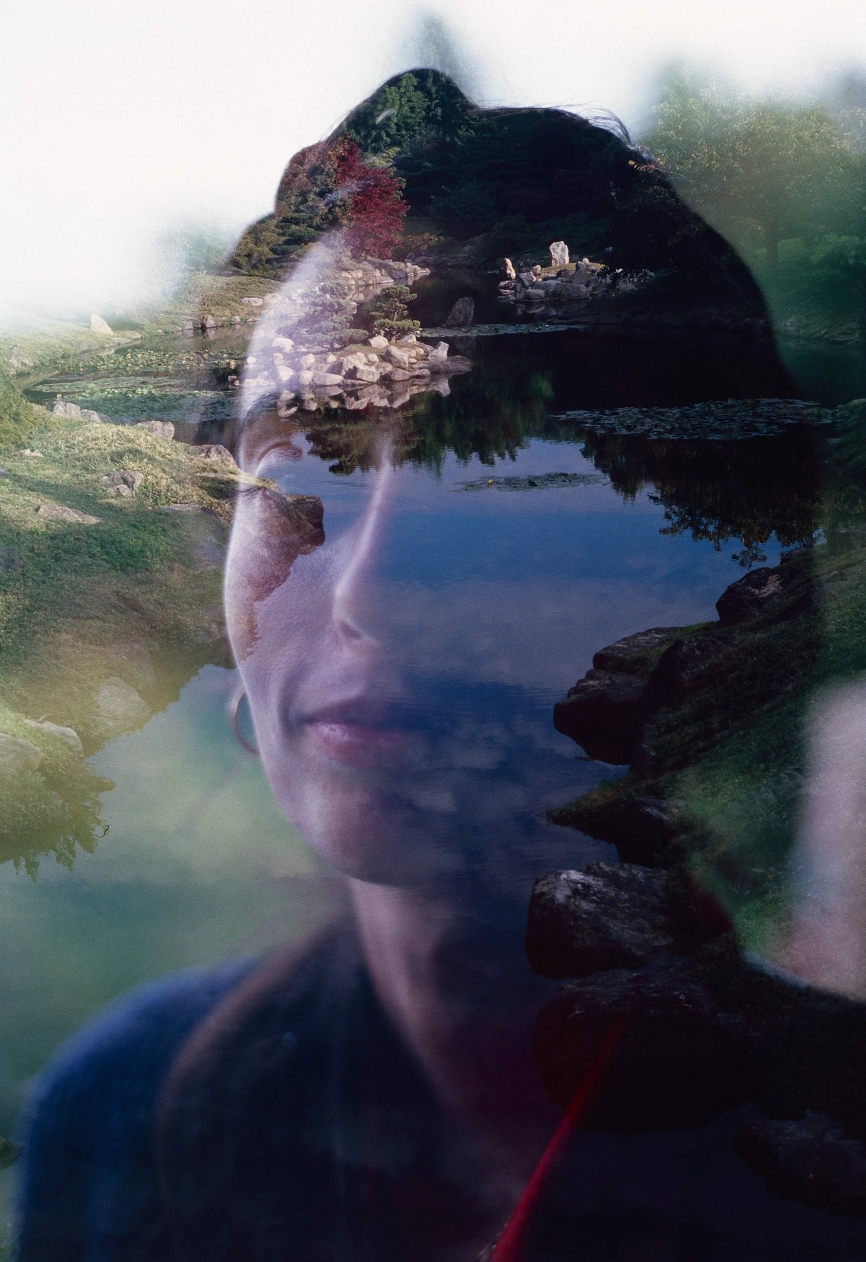 Superposition d'un visage et d'un paysage avec lac et végétation.