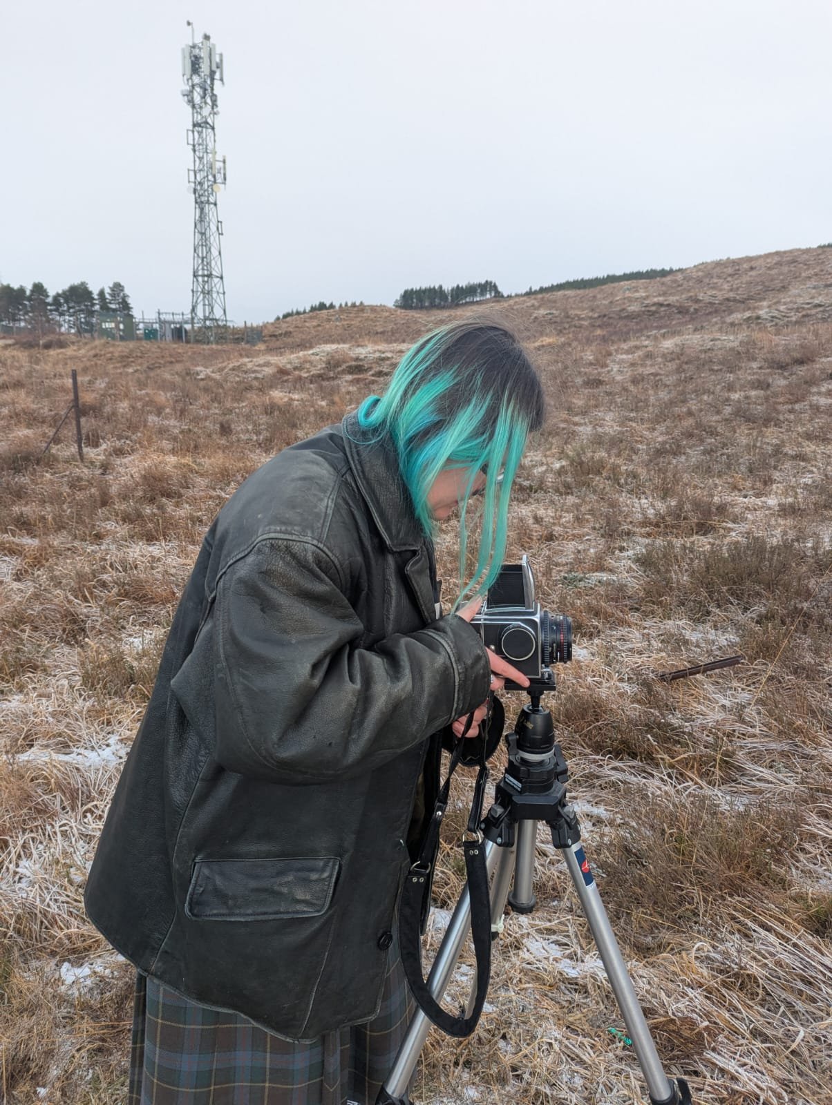 Photograph of photographer setting up camera in a field.