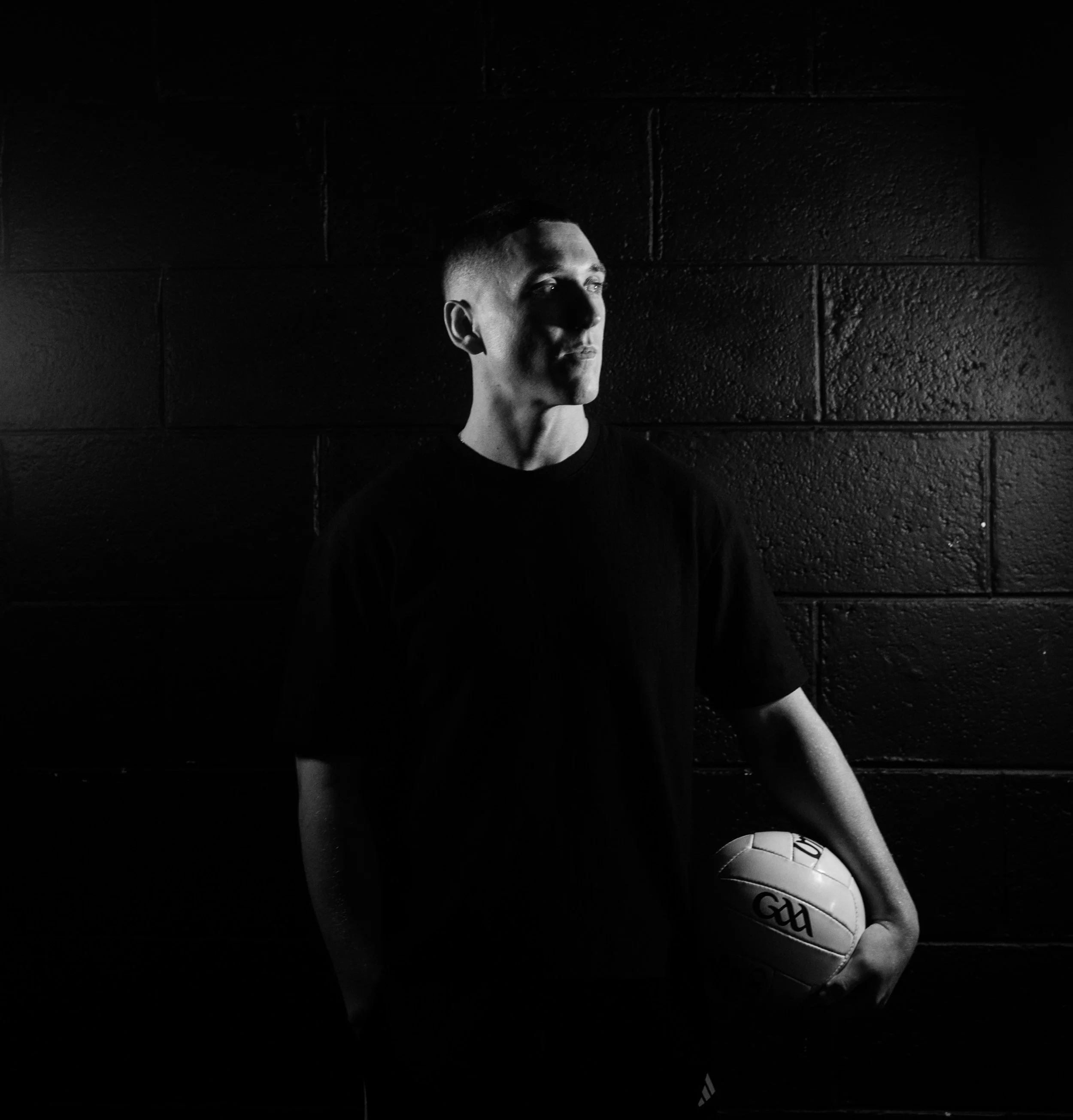 A man in a sports jersey holding a large trophy above his head, celebrating a victory at a sports event.