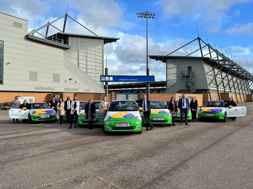 team at Boydens standing by their branded cars