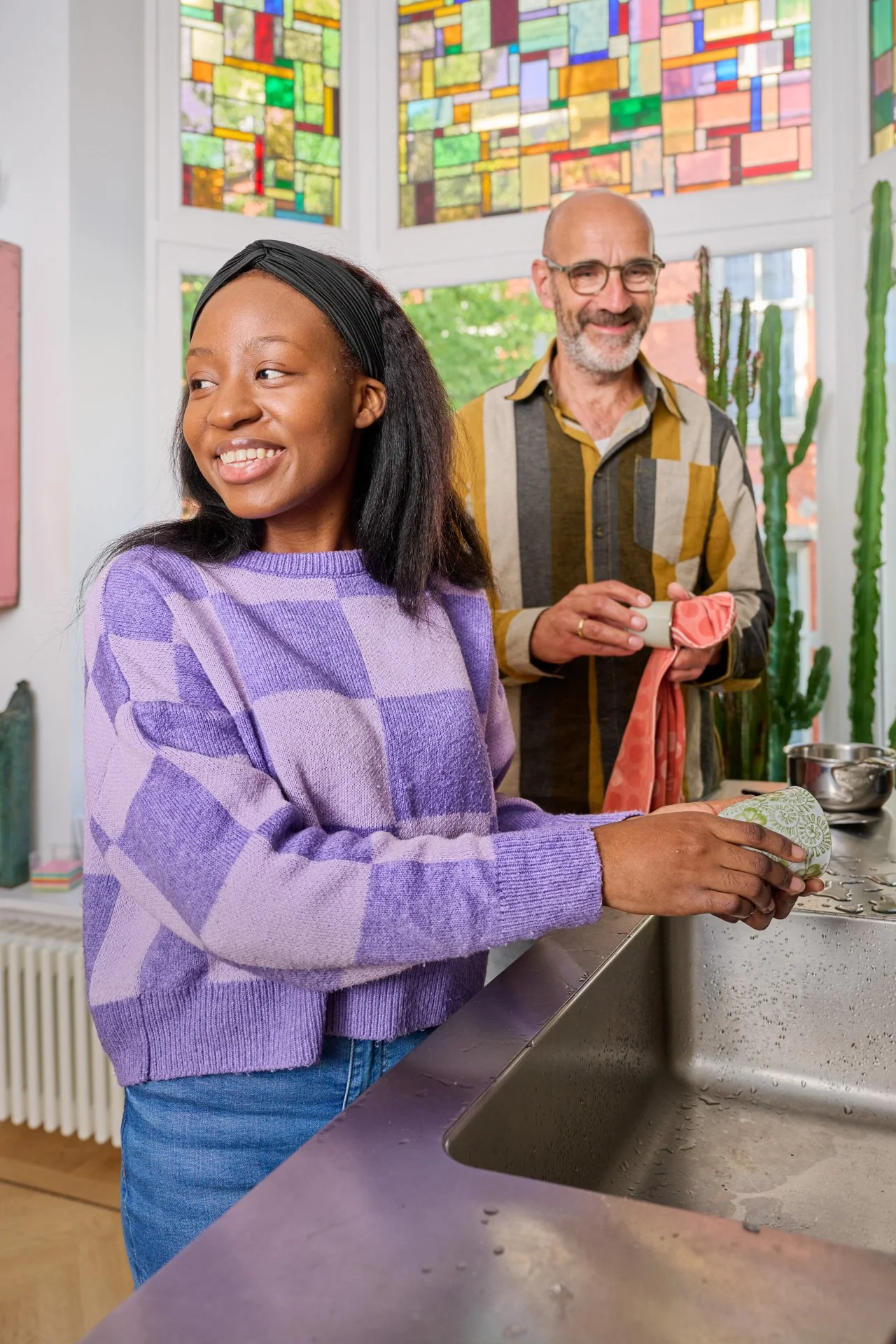 Een jonge vrouw staat af te wassen terwijl een man afdroogt