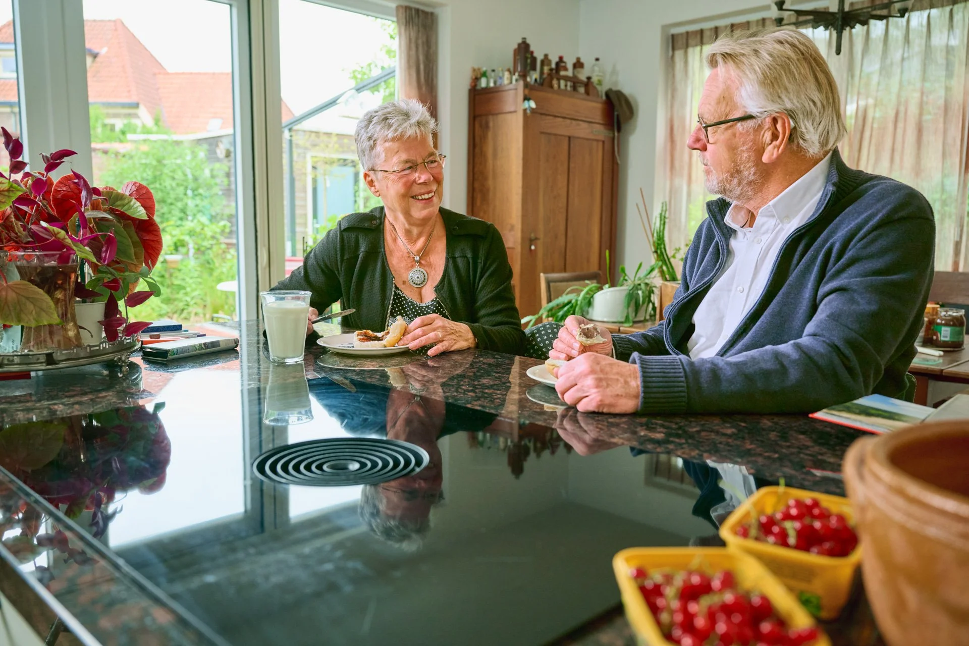 Een echtpaar is aan het lunchen in de keuken. 
