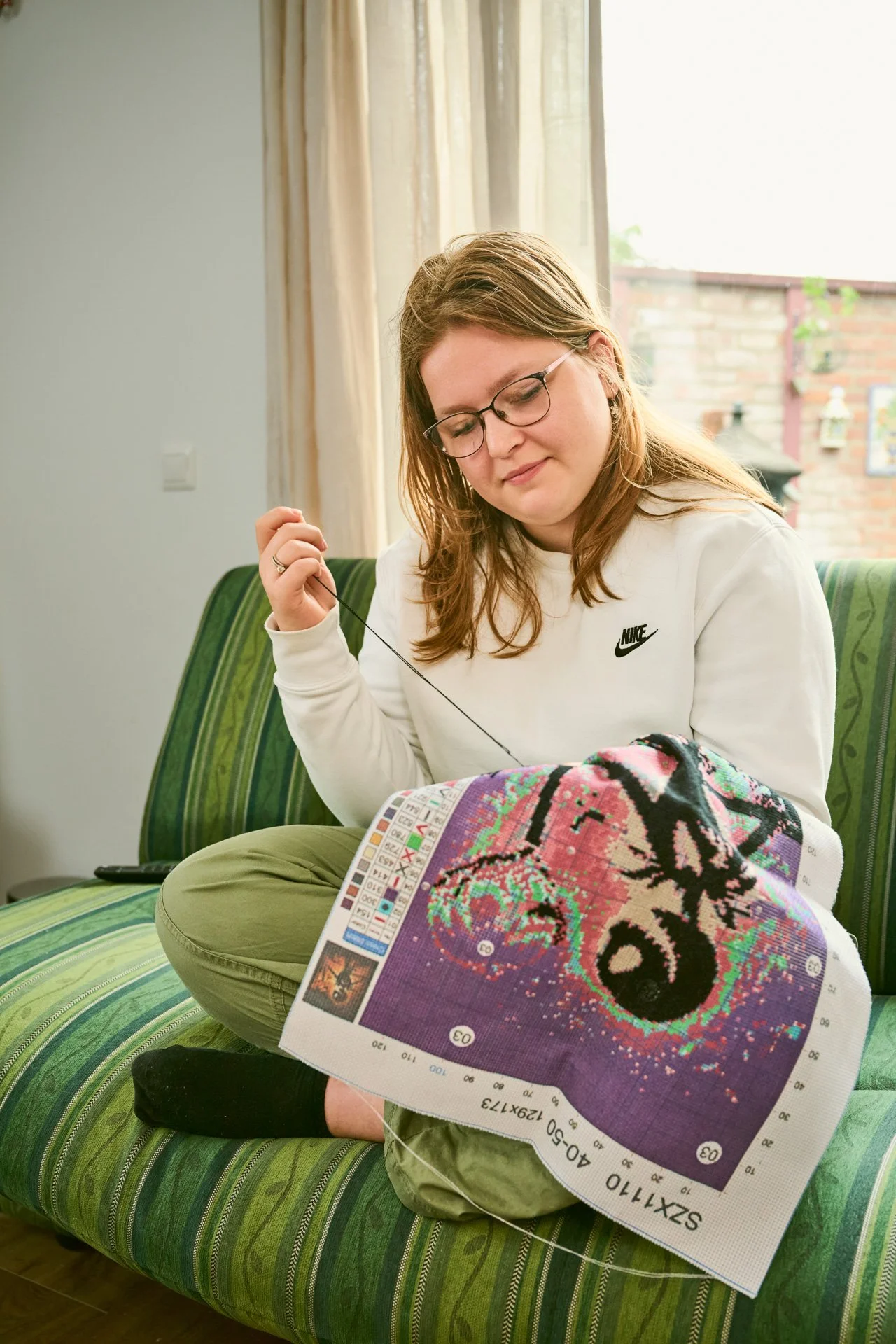 Een jonge vrouw is aan het borduren. 