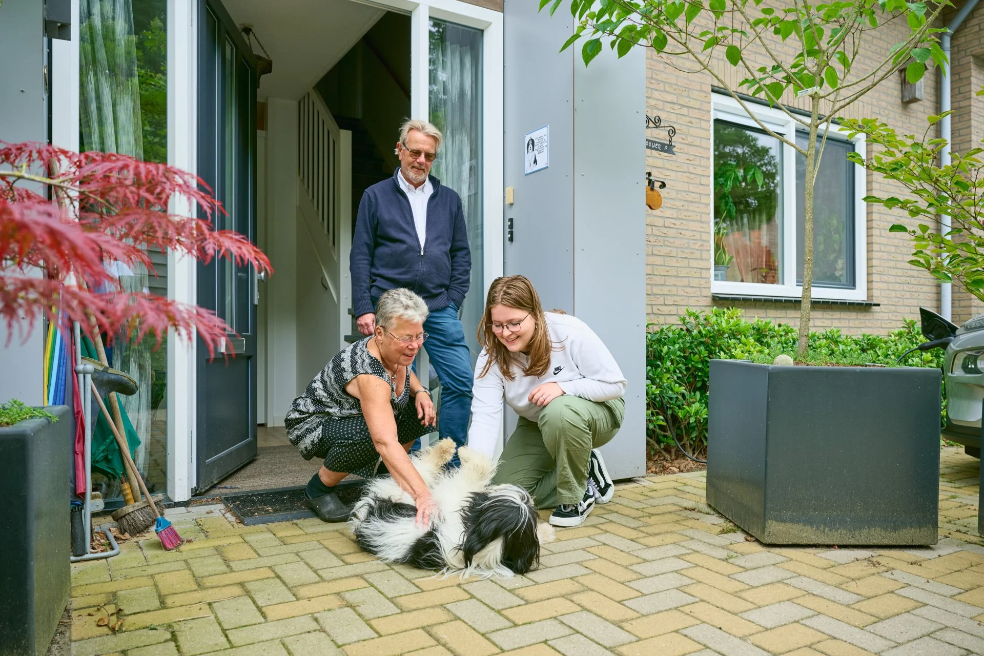 Een gezin speelt met de hond.