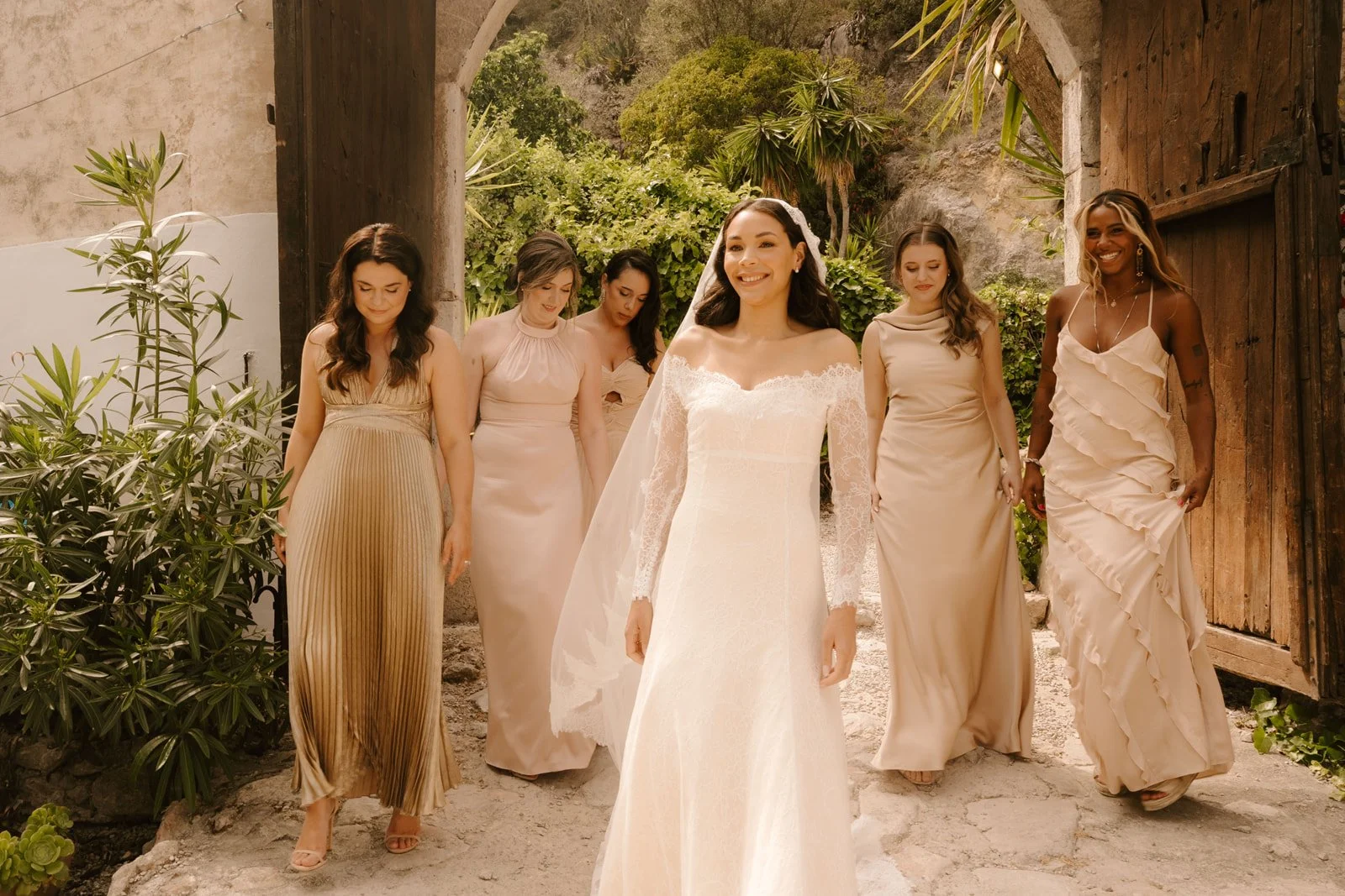 Bride and bridal party walking through wooden door