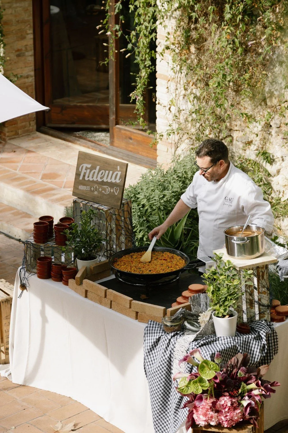 Chef preparing traditional Catalan fideuà for a wedding celebration in Barcelona