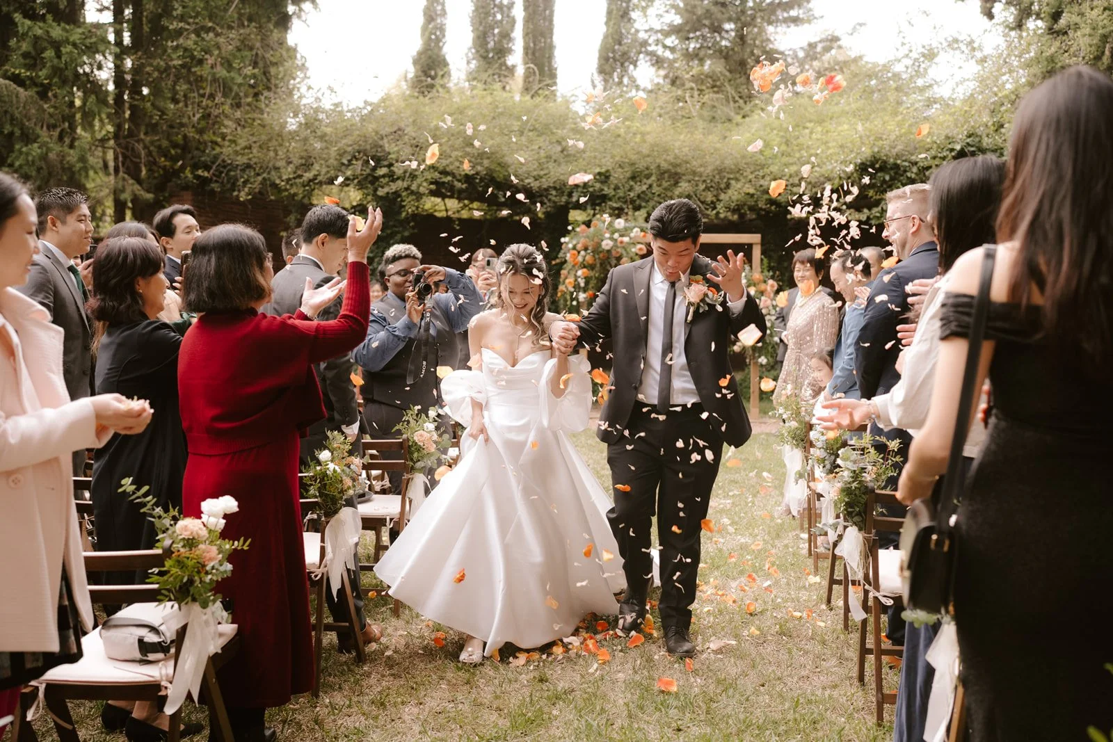 Couple leaving their november ceremony under a rain of petals at La Centenaria