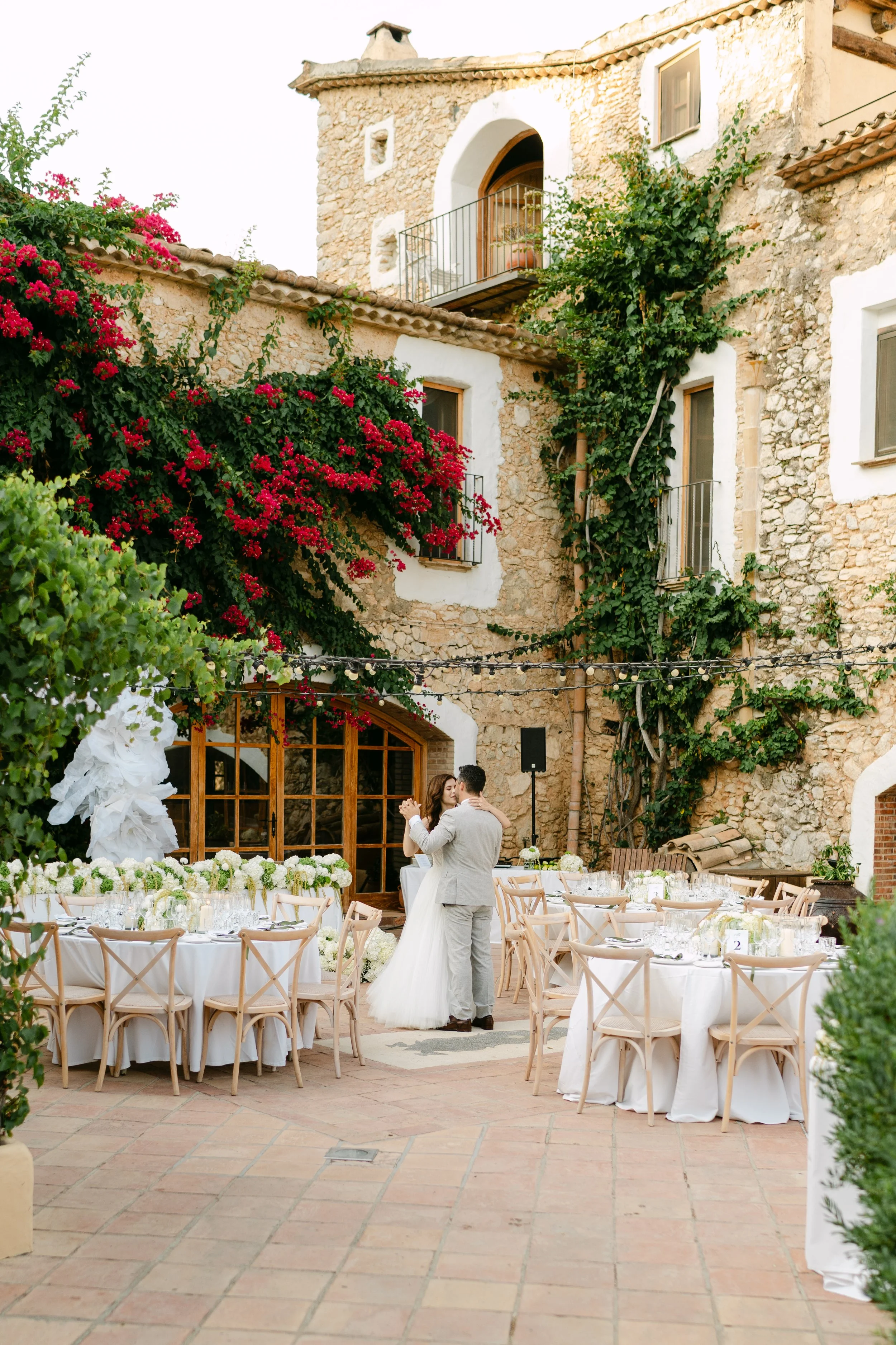 Newlyweds dancing during their wedding celebration with Almiral de la Font in the background.