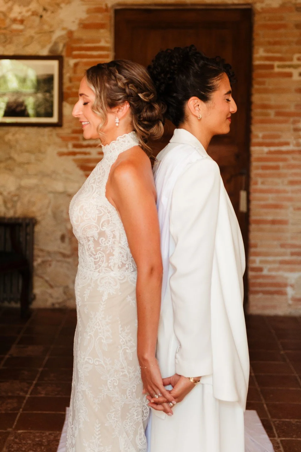Two brides sharing a first look and touch before their wedding ceremony in Barcelona